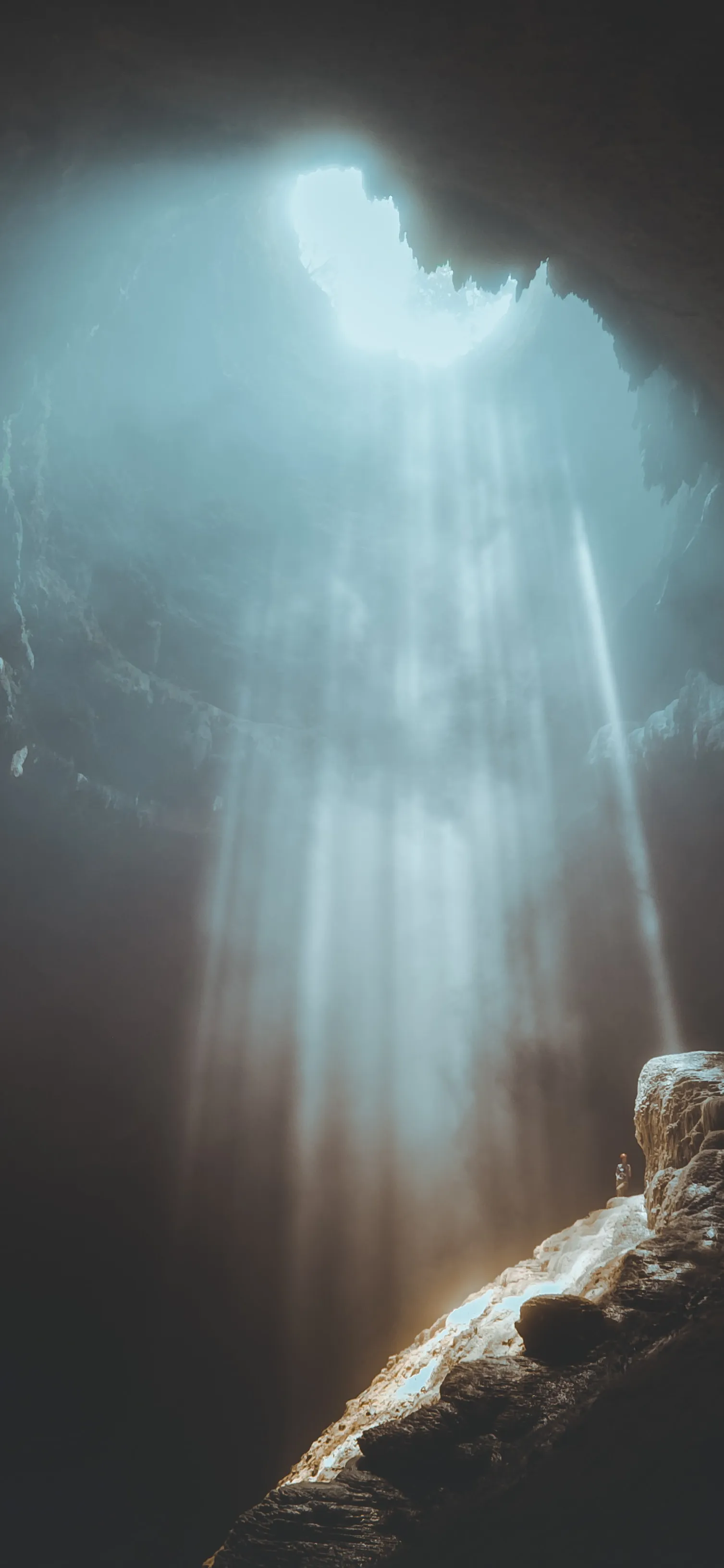 Person Looking Out From Inside Bright Cave Wallpaper