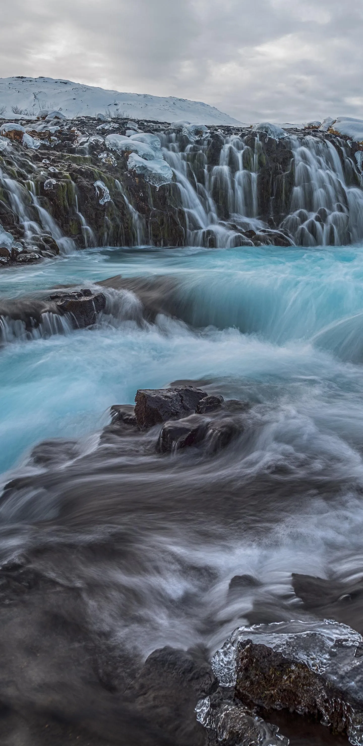 Powerful Waterfall Over Rocks in Cold Mountain Environment
