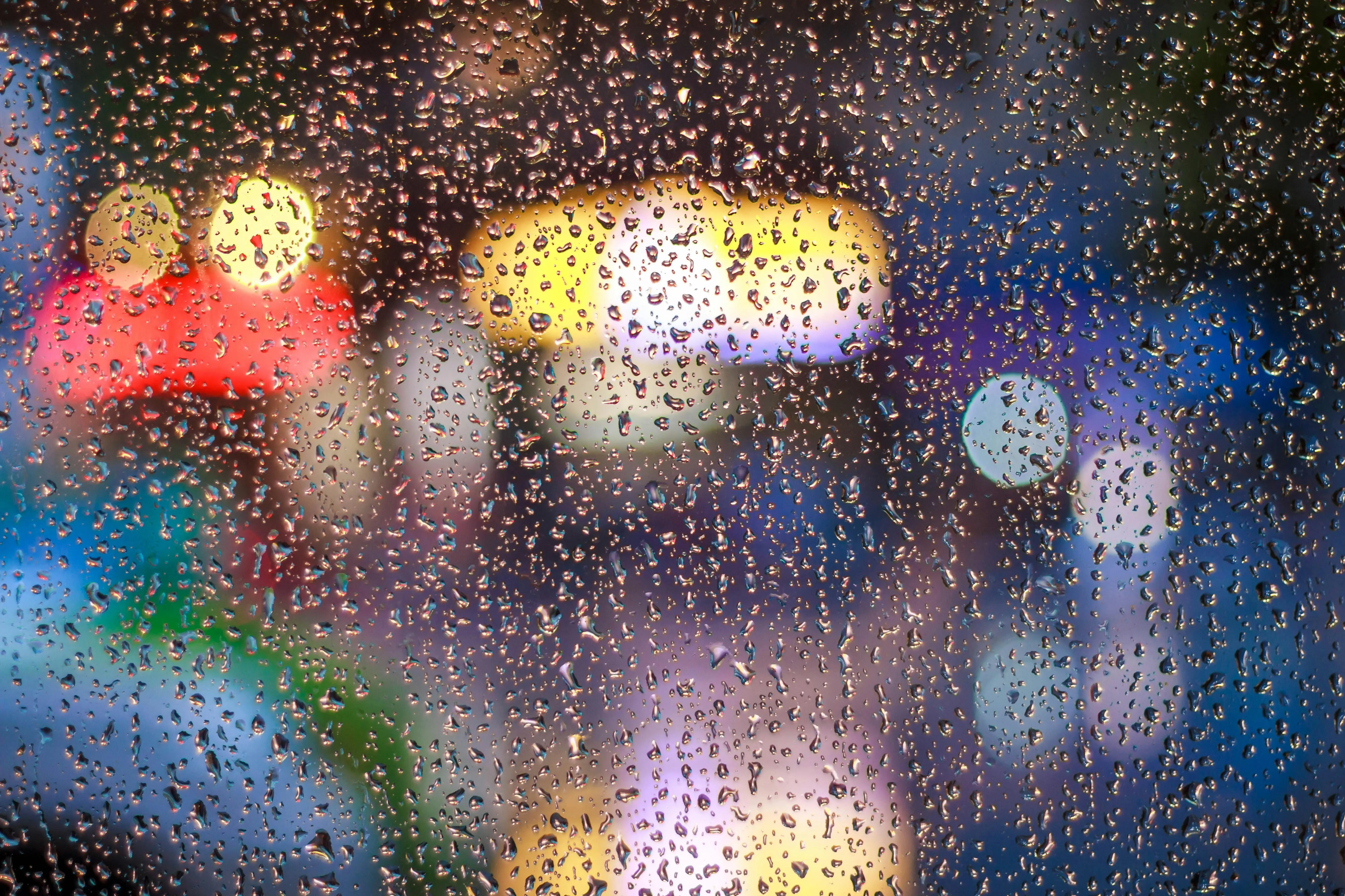Raindrops on the window with colourful city lights Wallpaper
