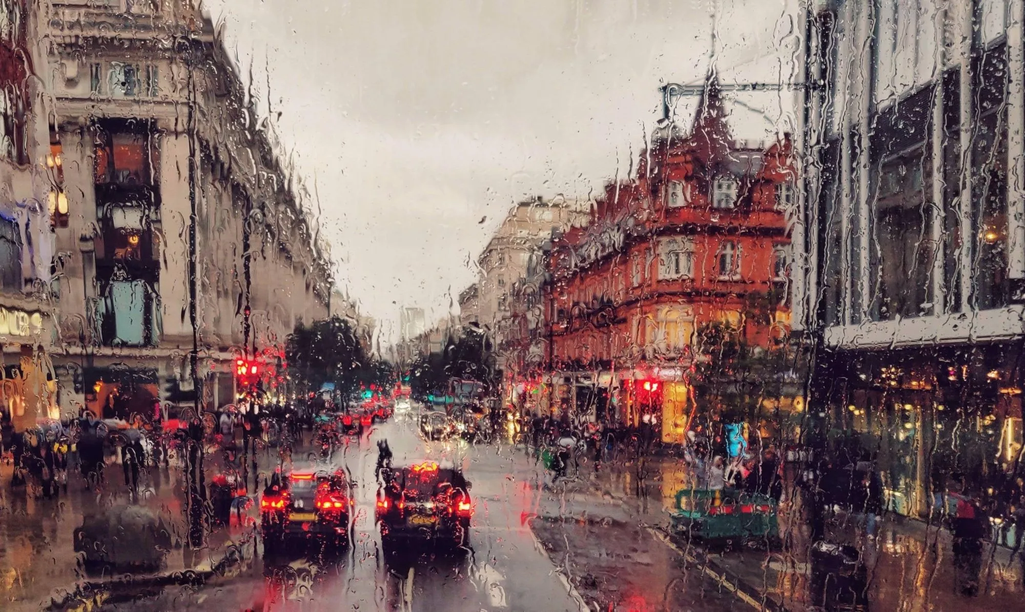 Rainy city street with cars and buildings during the evening