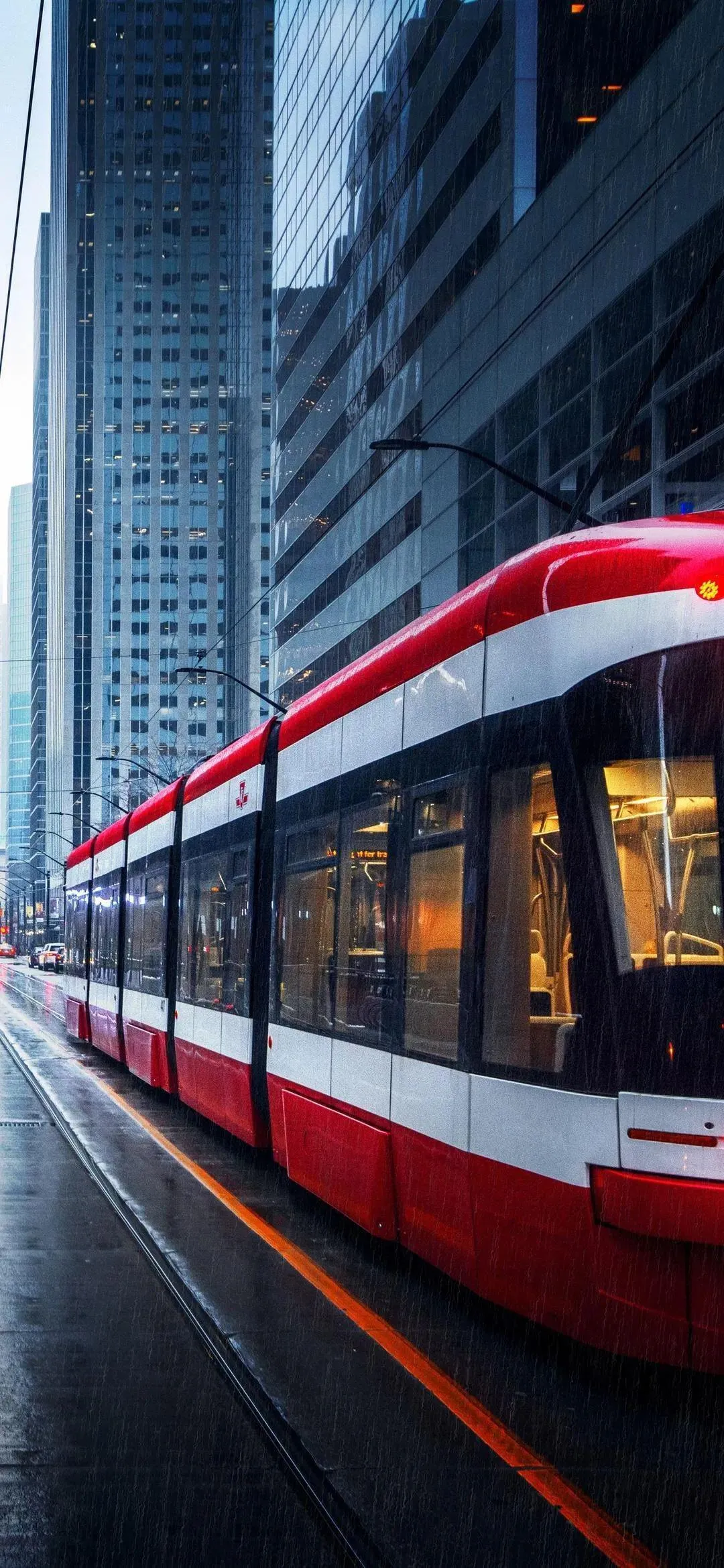 Red Tram Moving Through Urban Night Street Scene Wallpaper