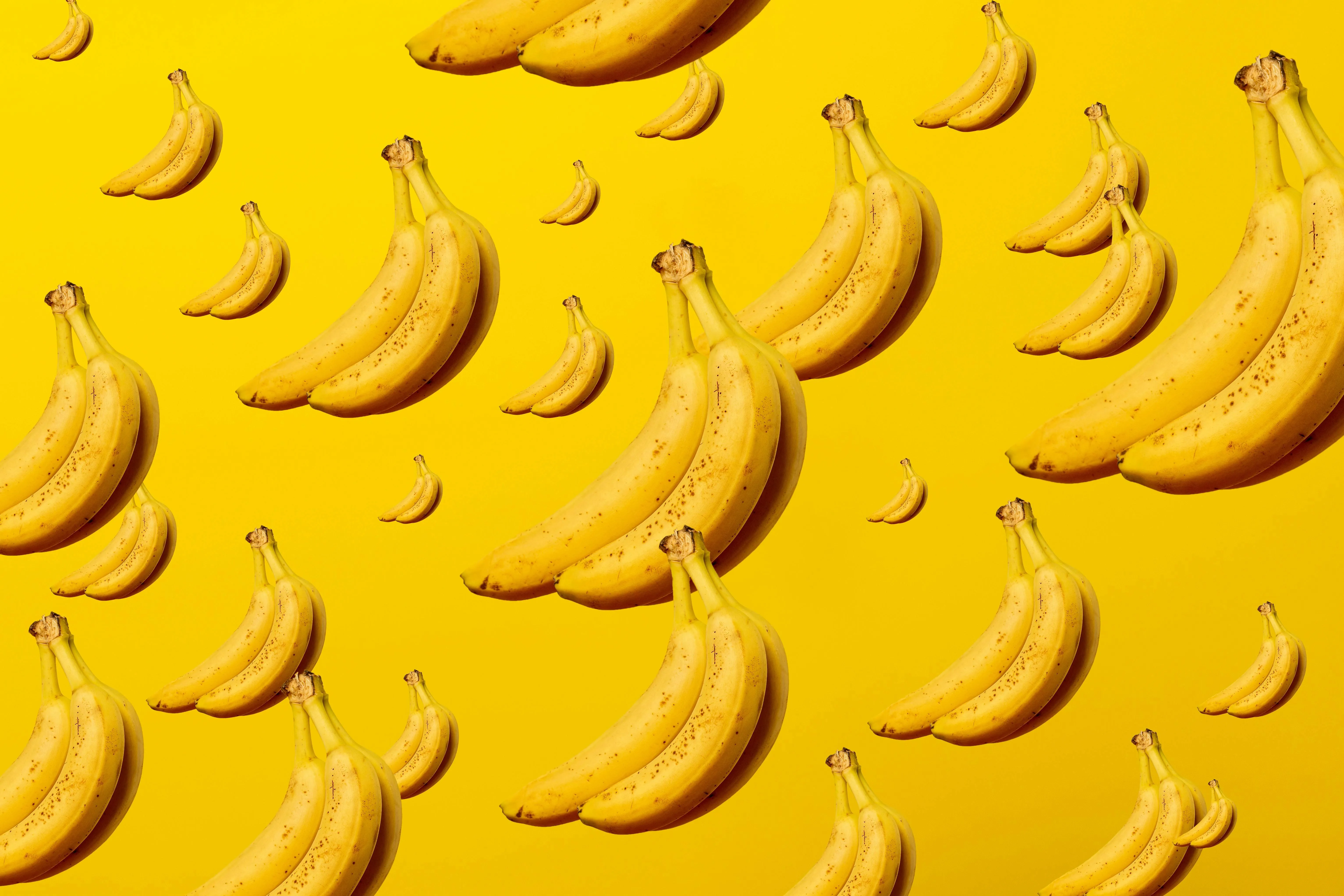 Ripe bananas pattern on a bright yellow background Wallpaper