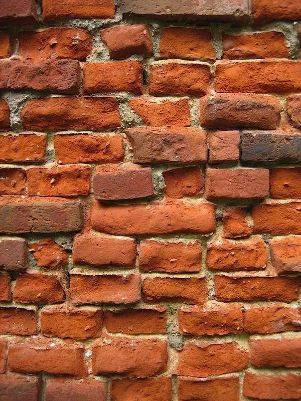 Rustic red brick wall with natural rough texture Wallpaper