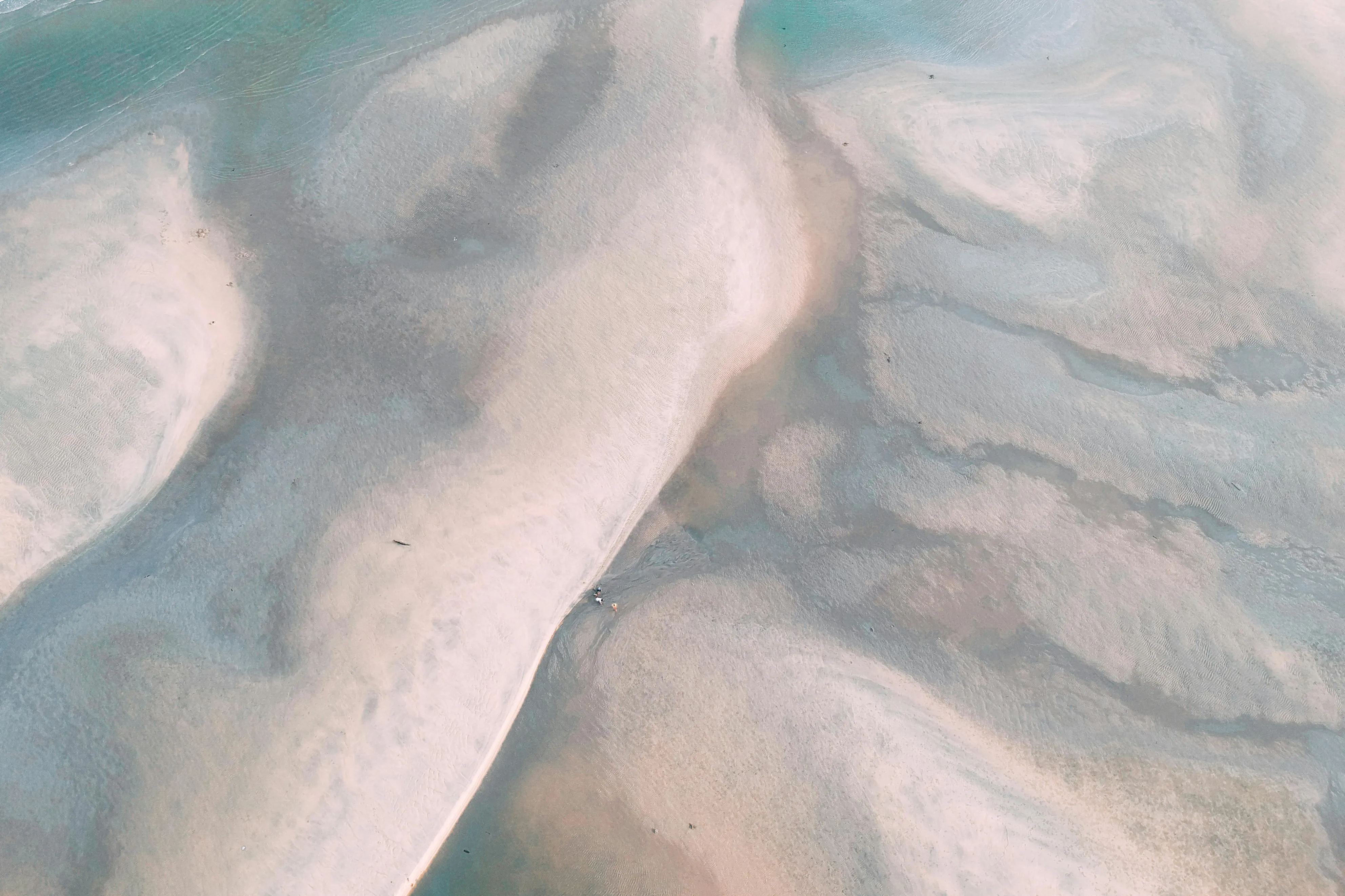 Sandy beach patterns and gentle blue water free Wallpaper