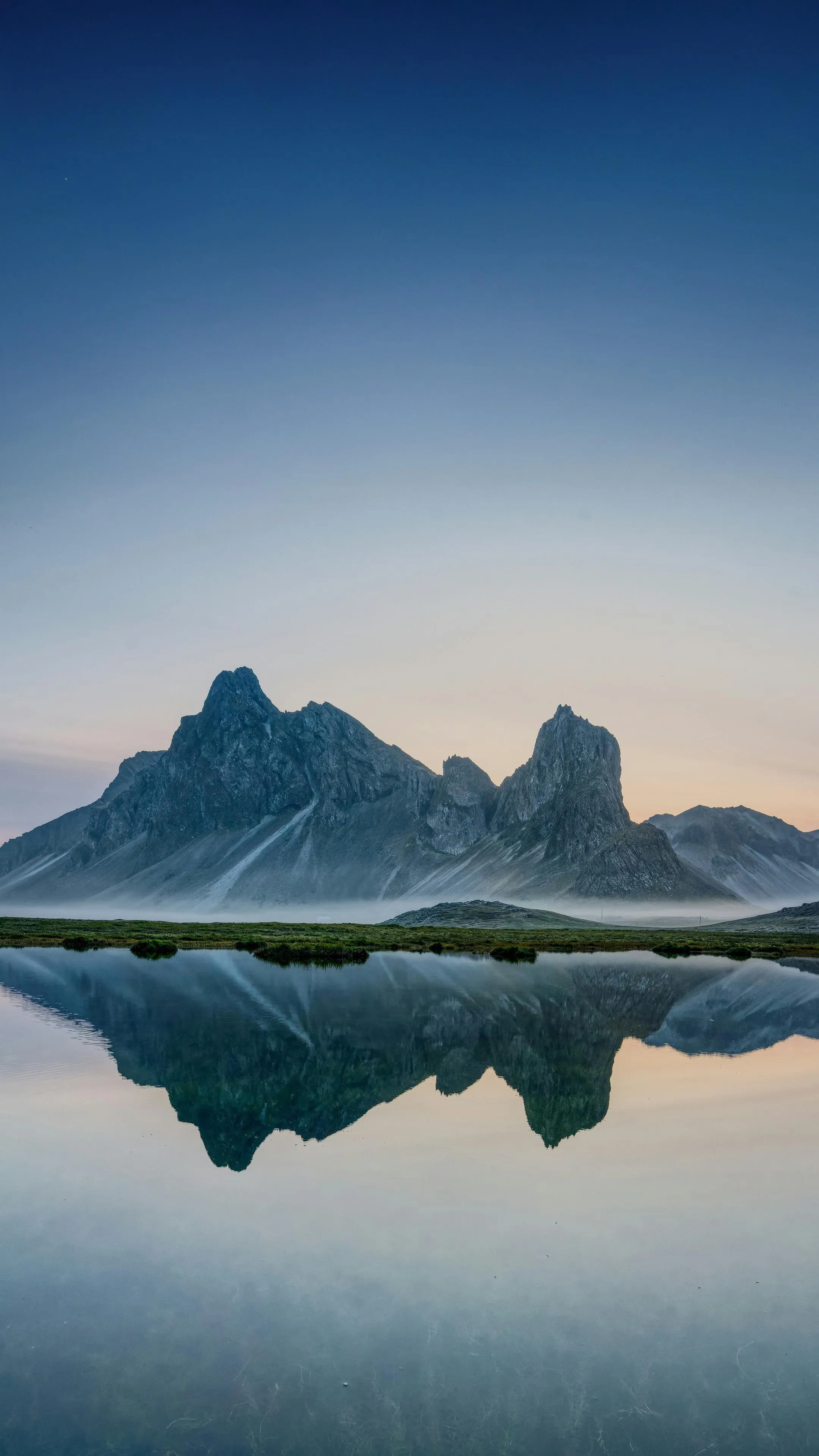 Serene Mountain Range Reflected Perfectly on Calm Lake Surface