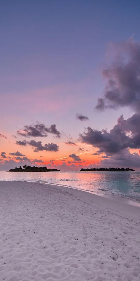 Serene sunset at the beach with calm ocean waves Wallpaper