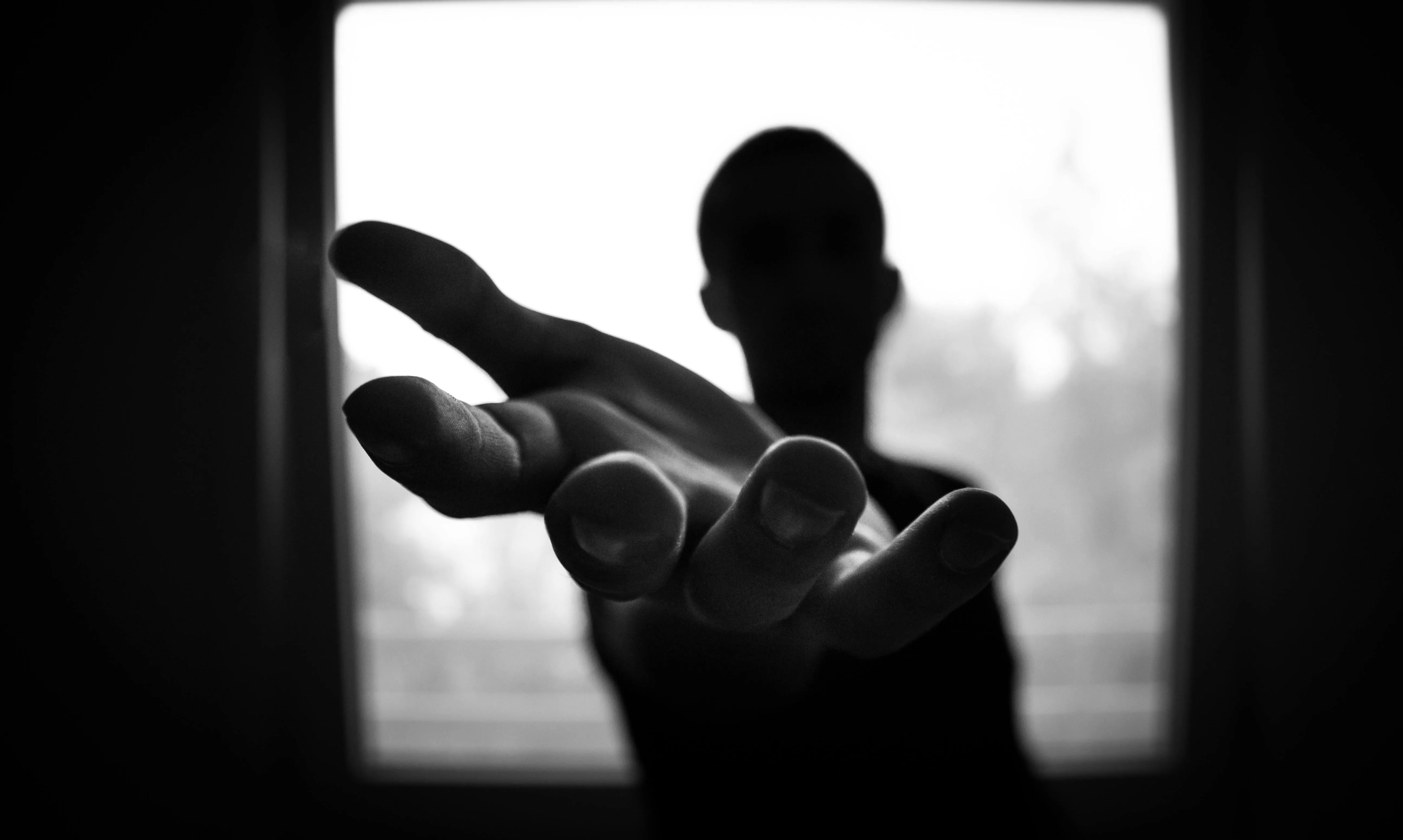 Shadow image of a person reaching hand towards the camera