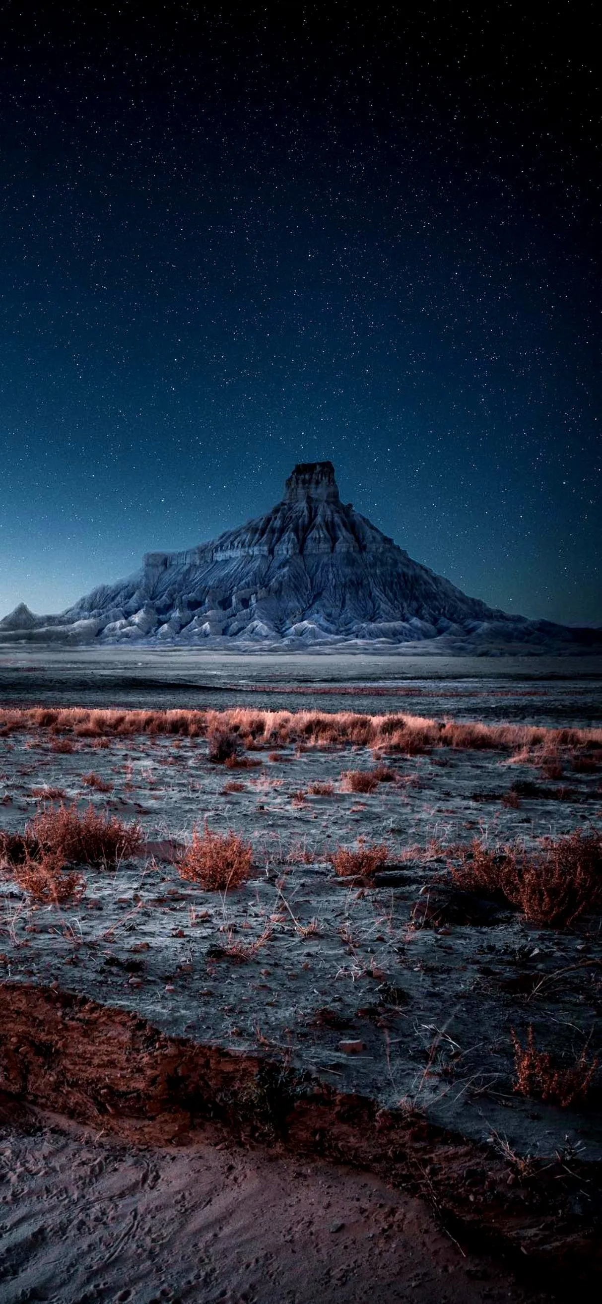 Sharp pointed mountain peak under dark blue sky Wallpaper