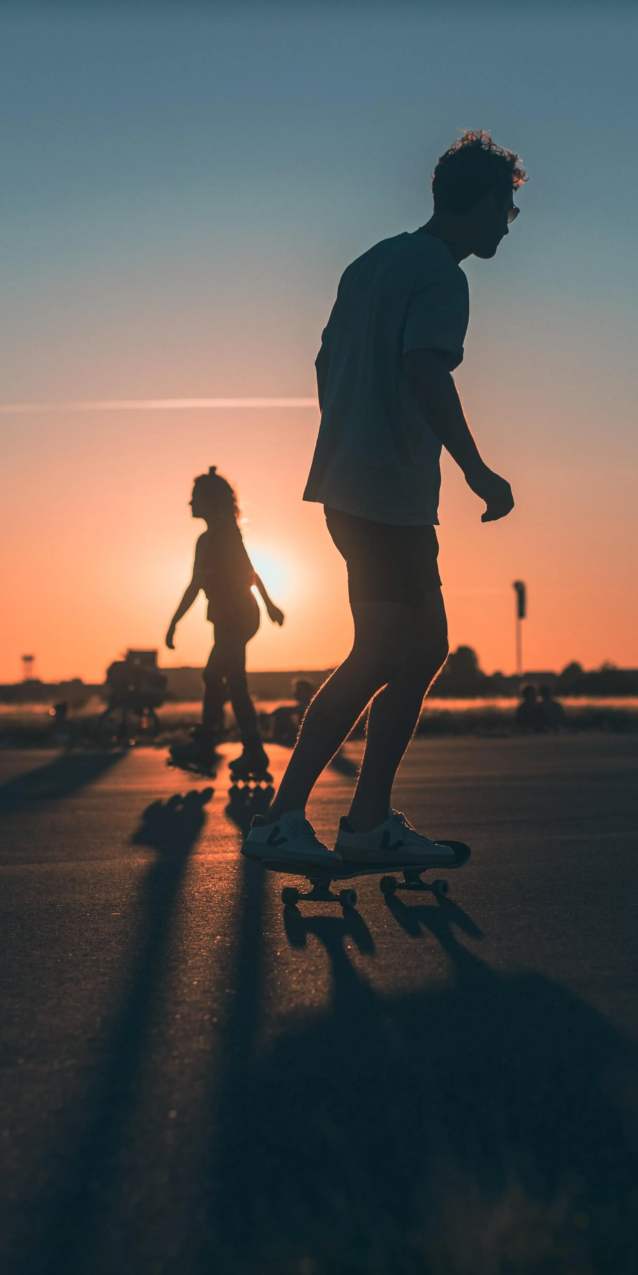 Silhouettes of People Walking in Sunset with Long Shadows