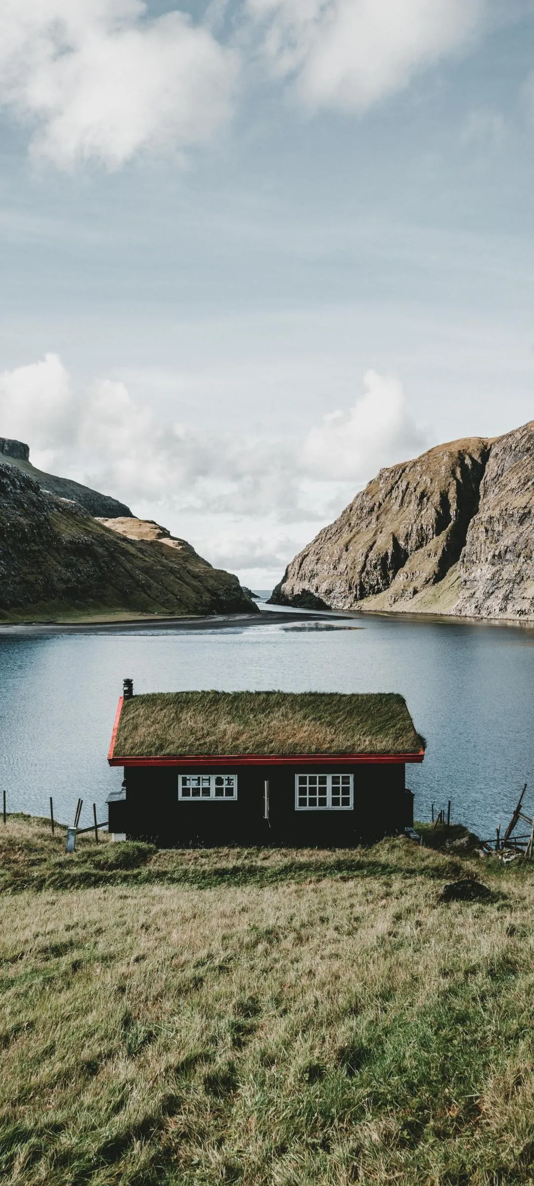 Small Cabin in Meadow with Mountains and Lake View Wallpaper