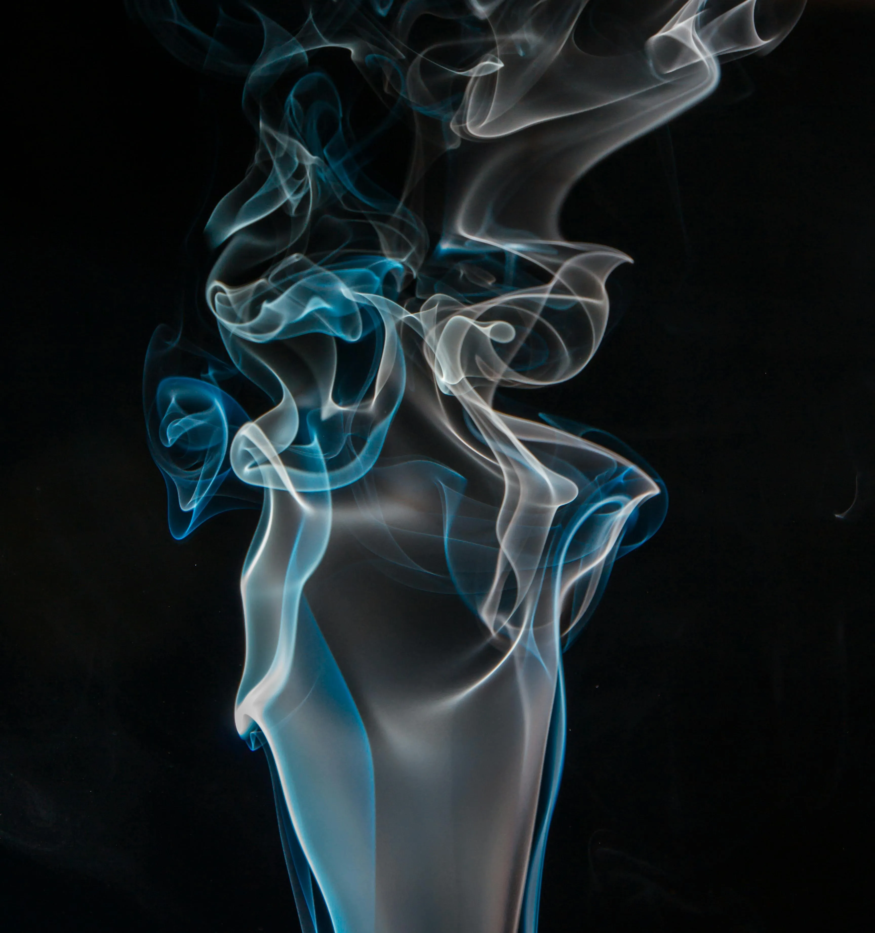 Smoke patterns in blue and gray on a black background image