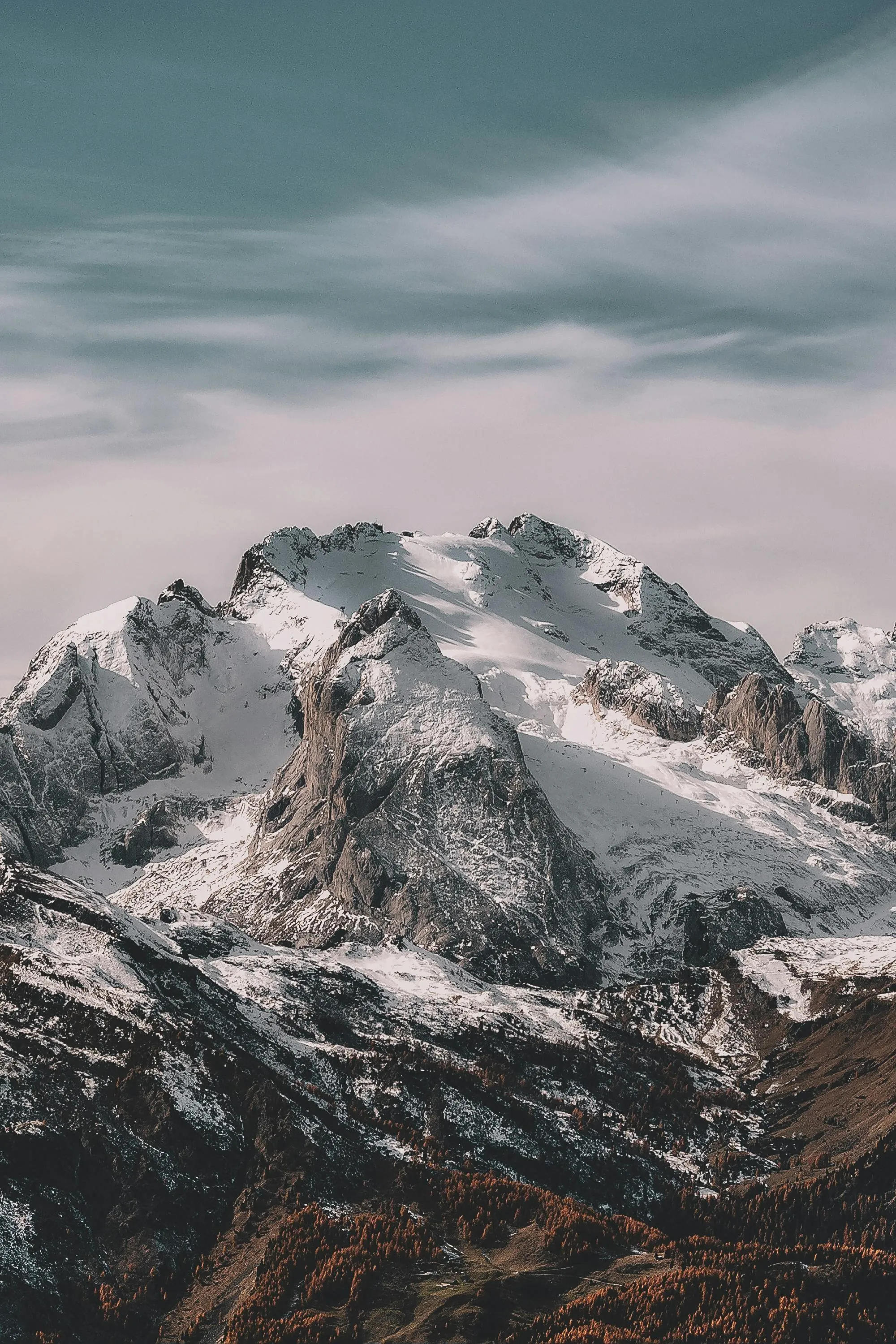 Snow covered mountains under a cloudy sky view Wallpaper