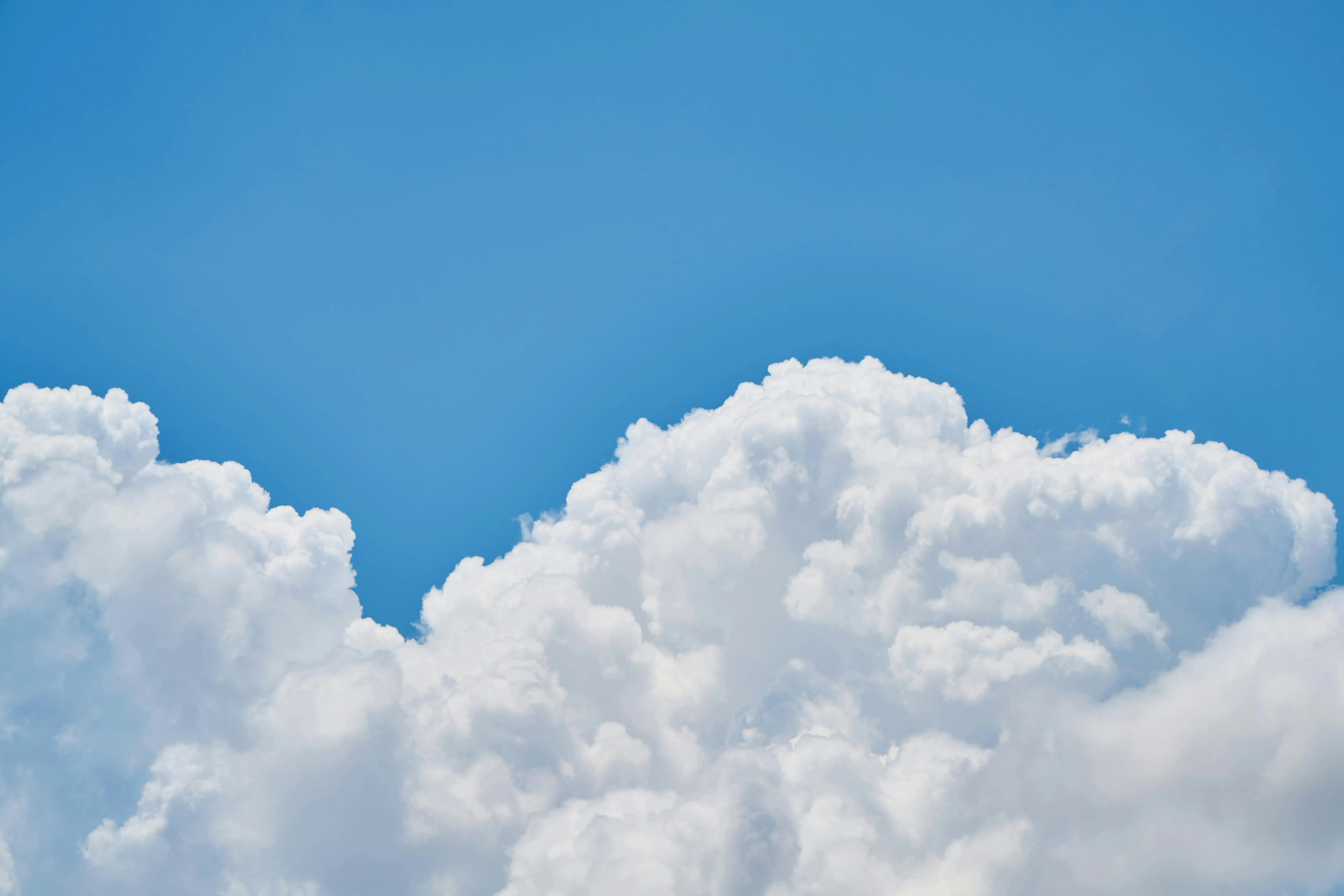 Soft white clouds against a clear blue sky free Wallpaper