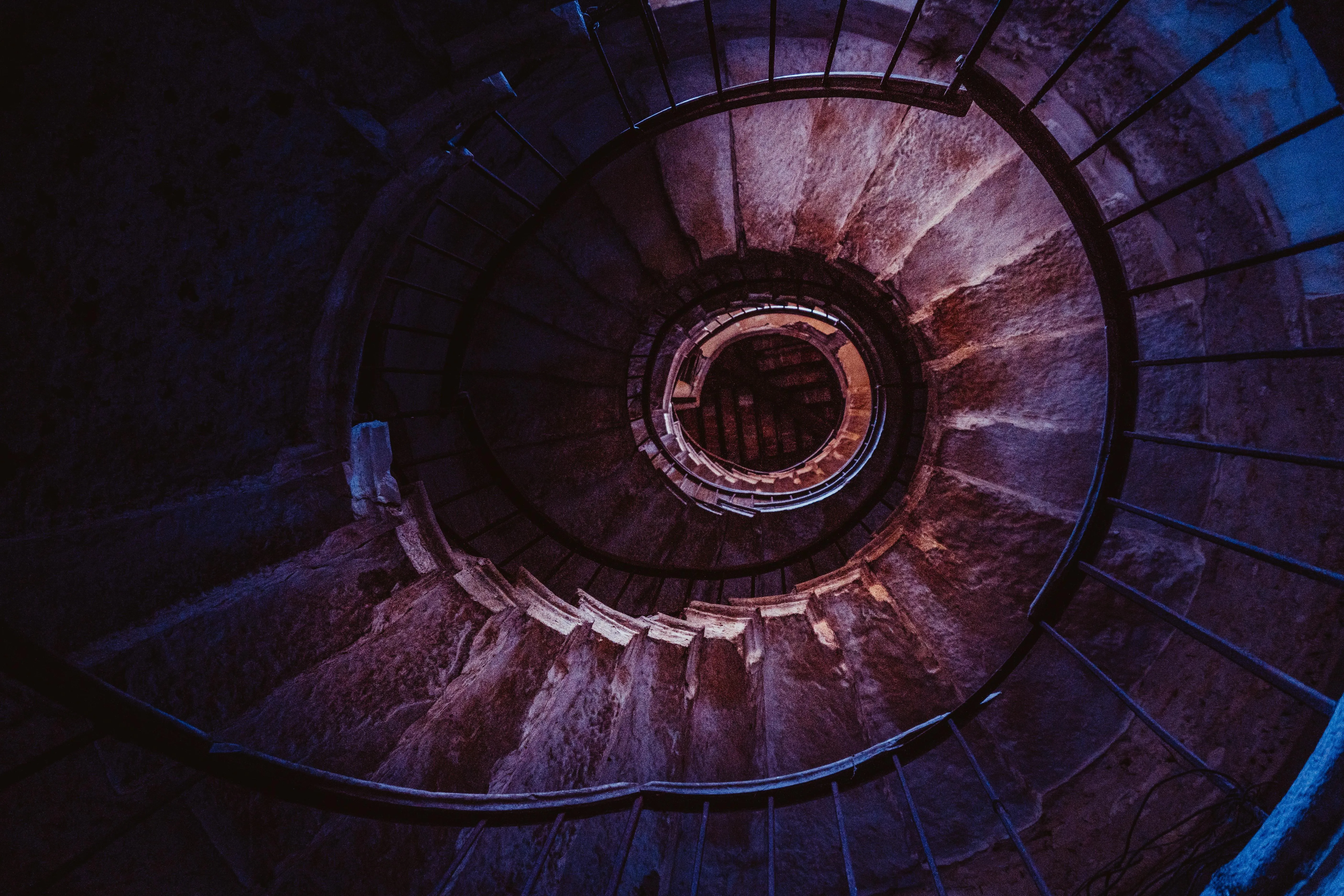 Spiral staircase viewed from above with moody lighting image