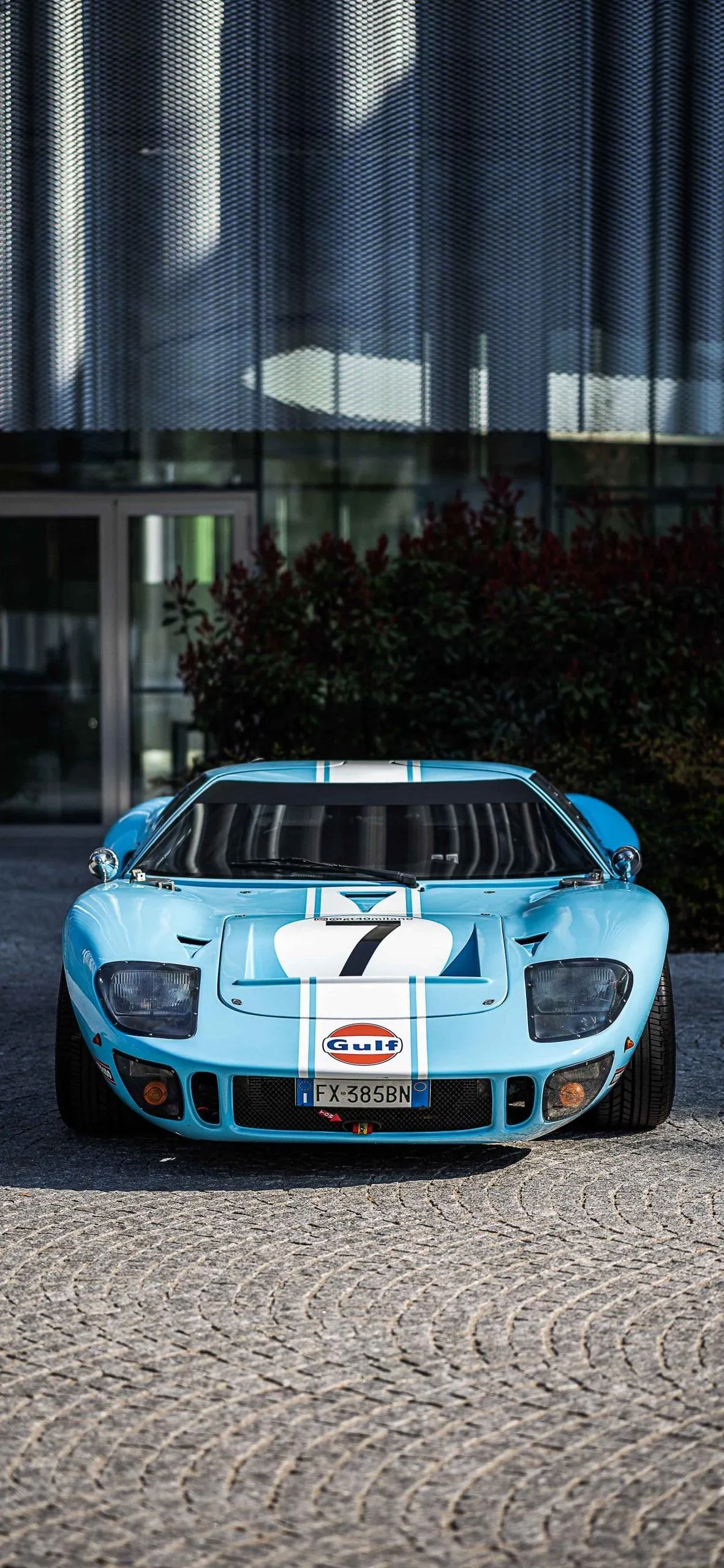 Sport Car Parked by Glass Building in City Background