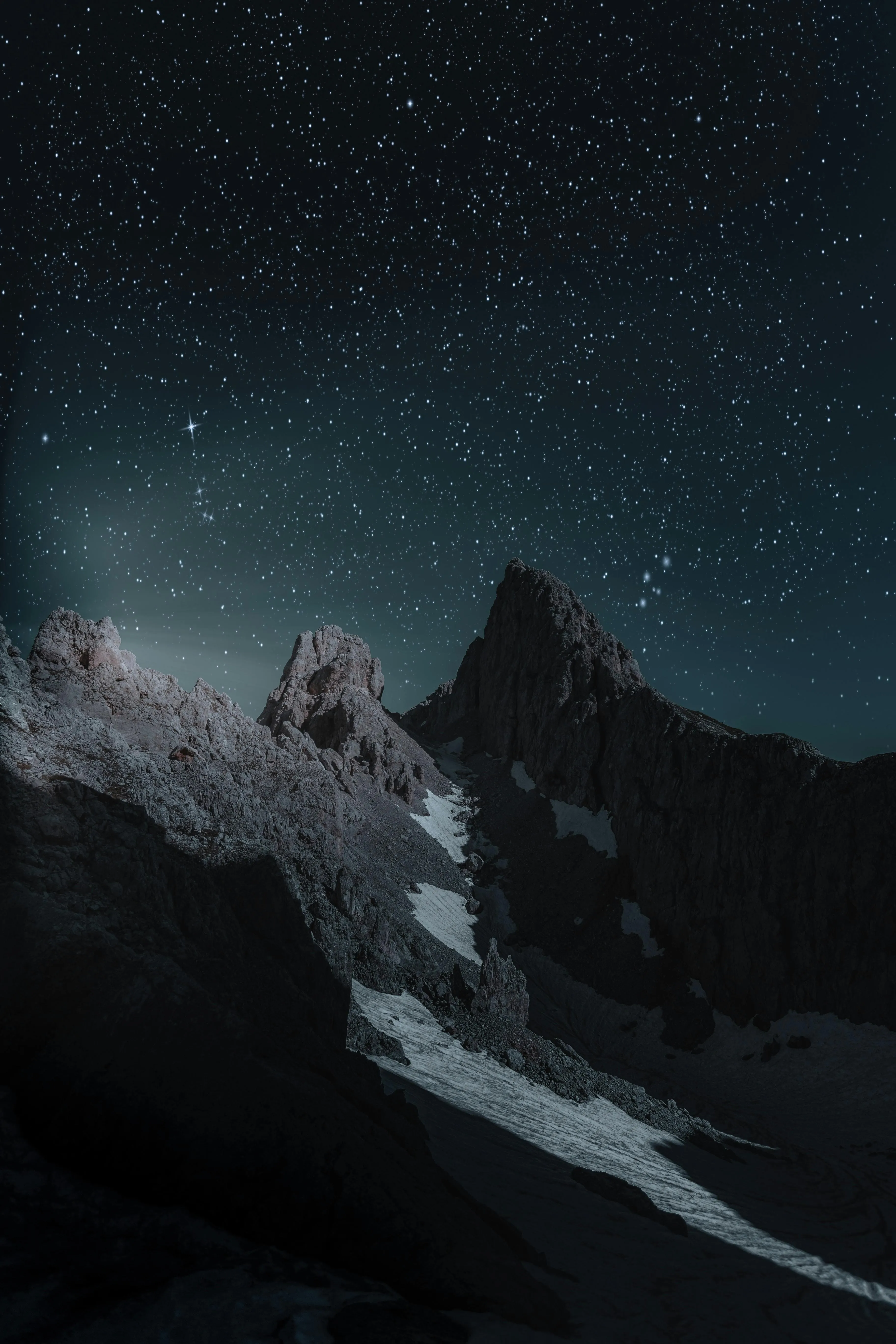Starry night over snowy mountain peaks with dark sky view