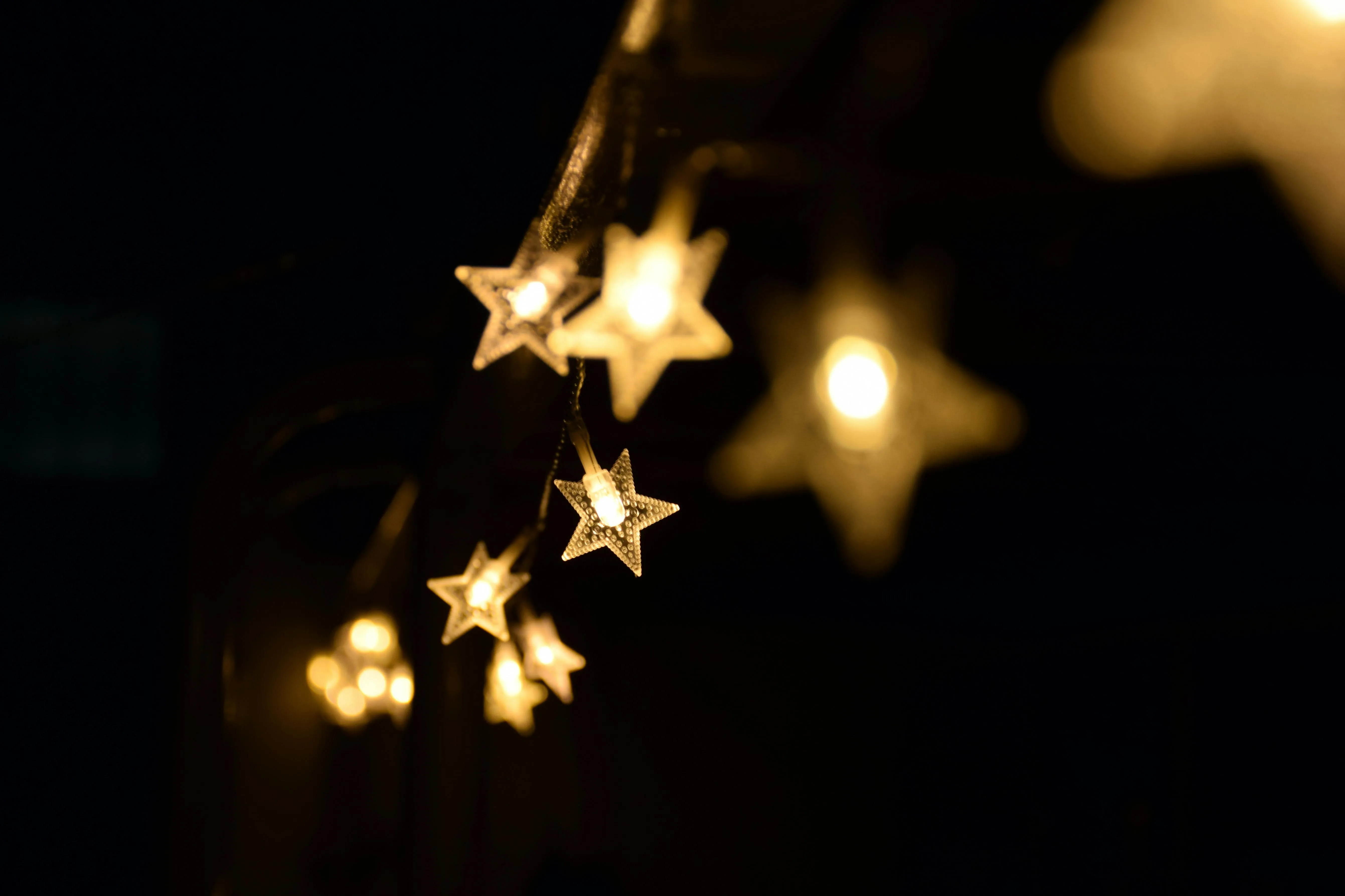 String of warm glowing star lights in a dark background