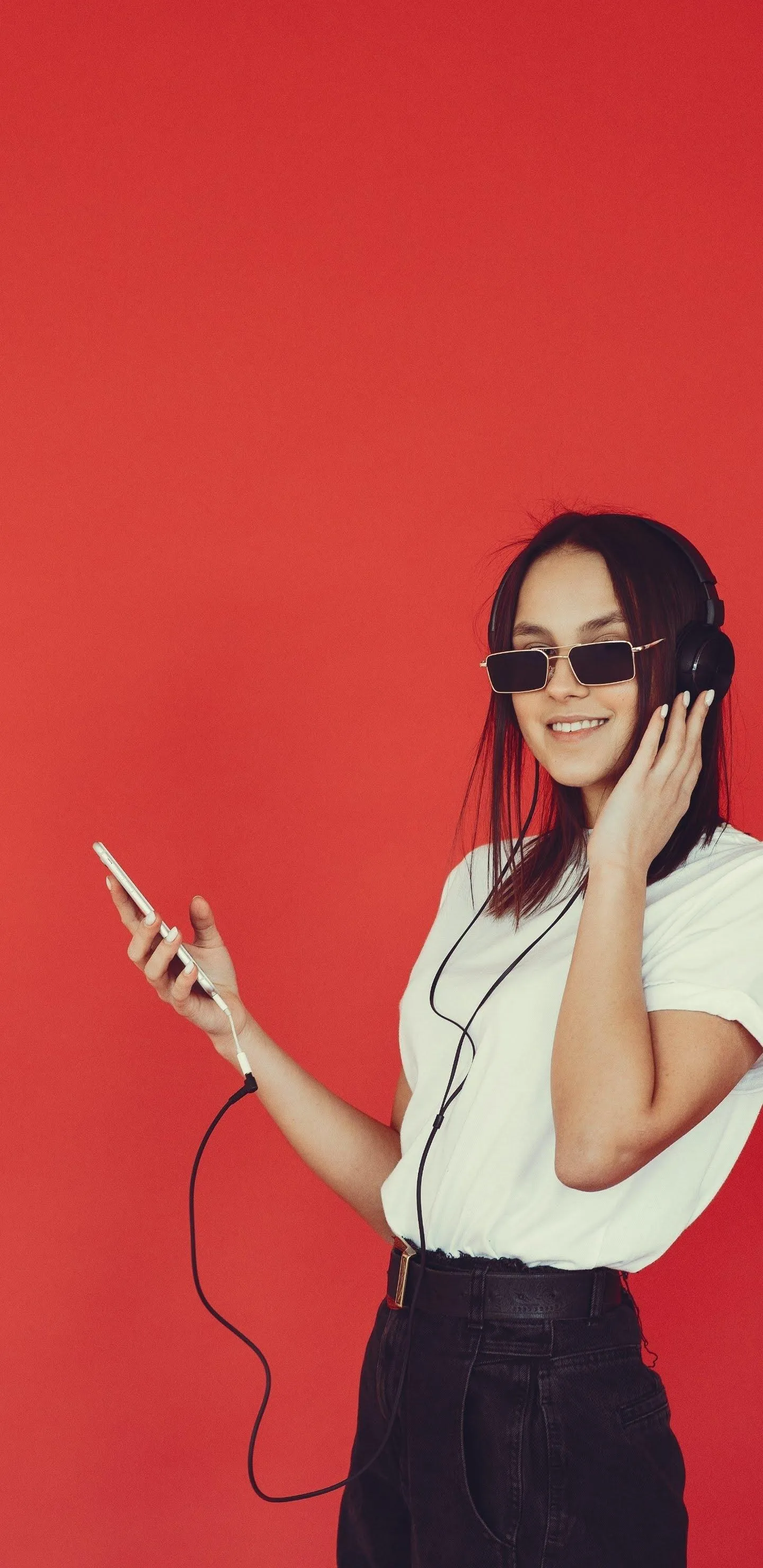 Stylish Woman Posing in Red Fashion Studio Background