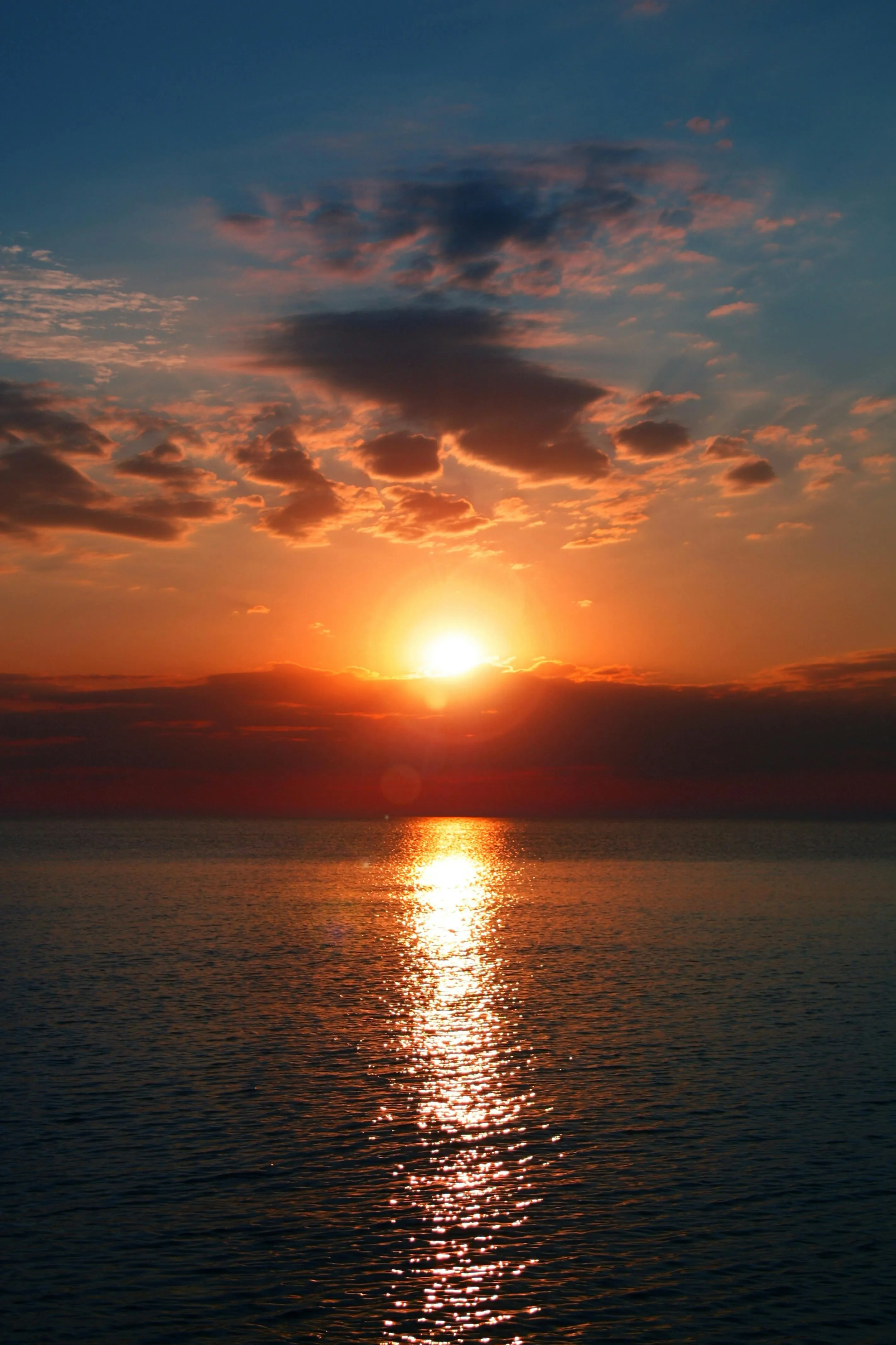 Sunset over calm ocean with golden reflection Wallpaper