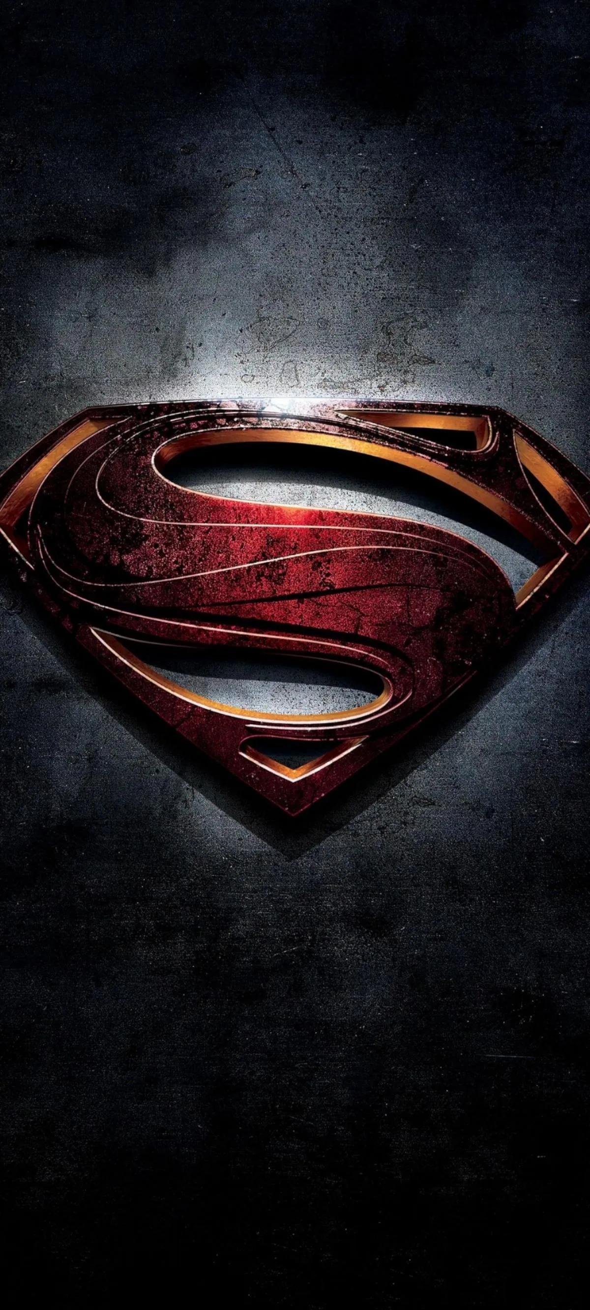 Superman logo in dramatic lighting on dark textured surface