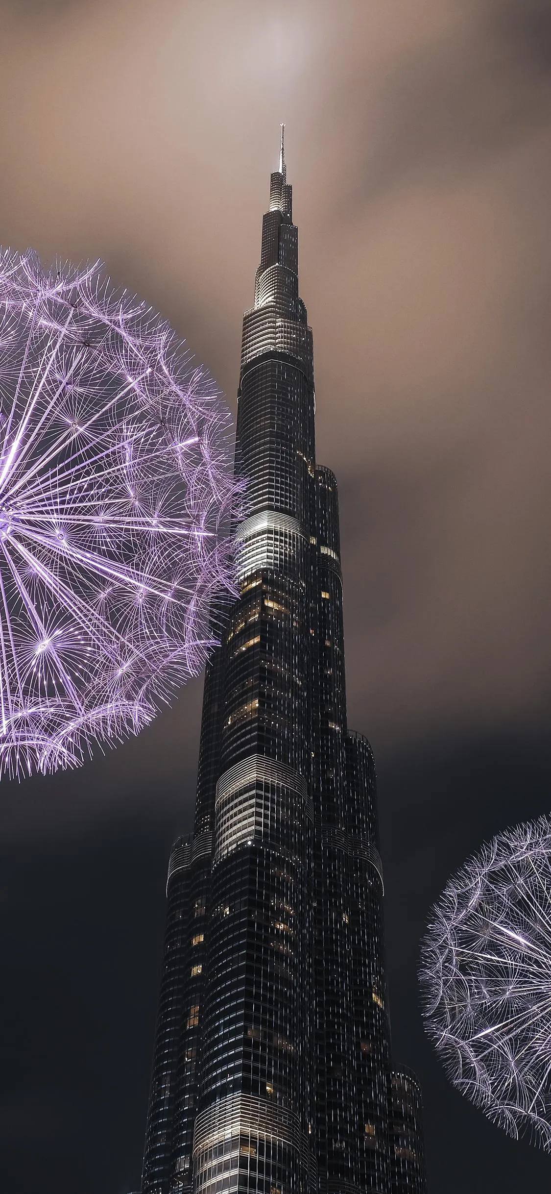 Tall Building Against Night Sky with Fireworks Wallpaper