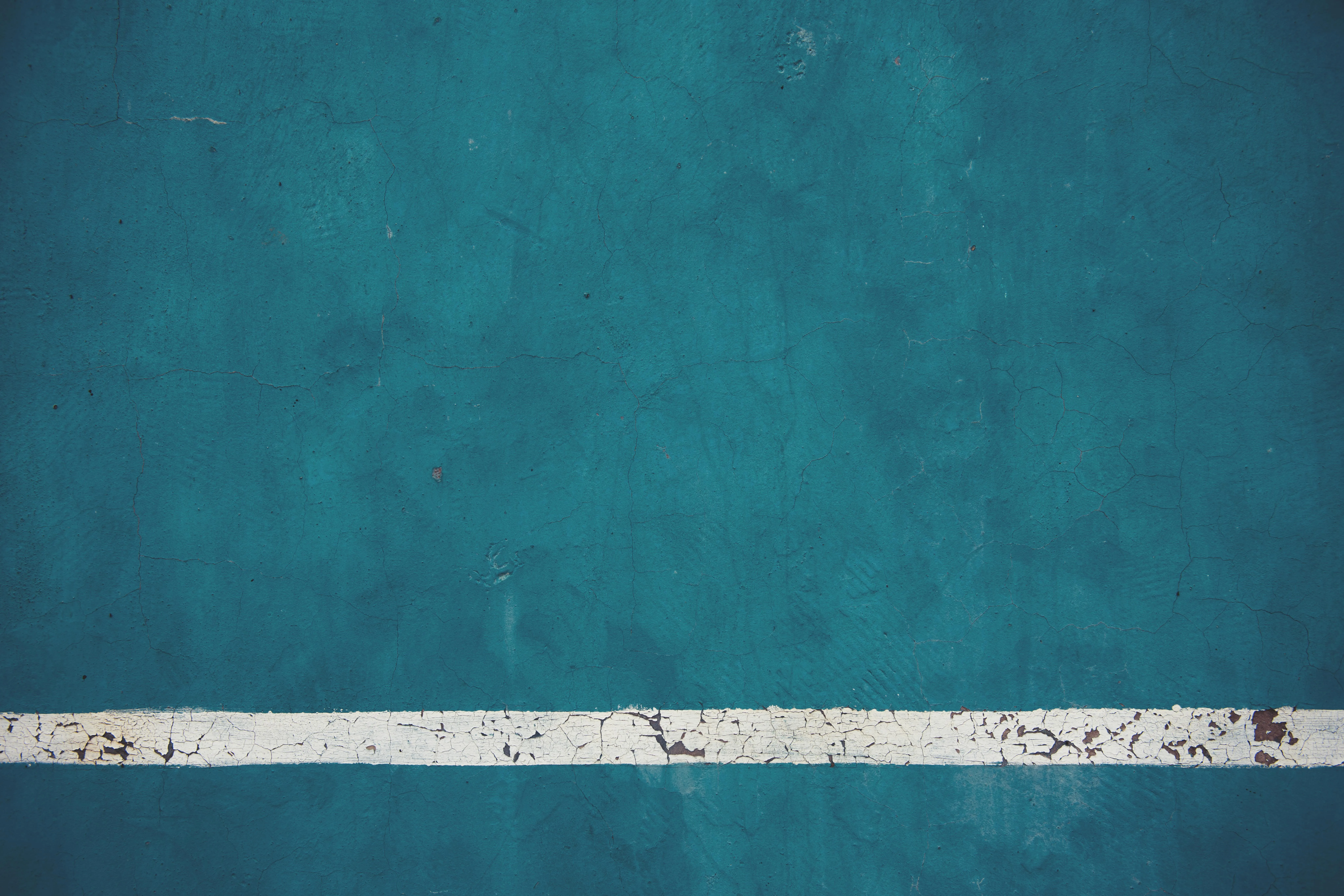Teal grunge wall with a white stripe across the bottom image