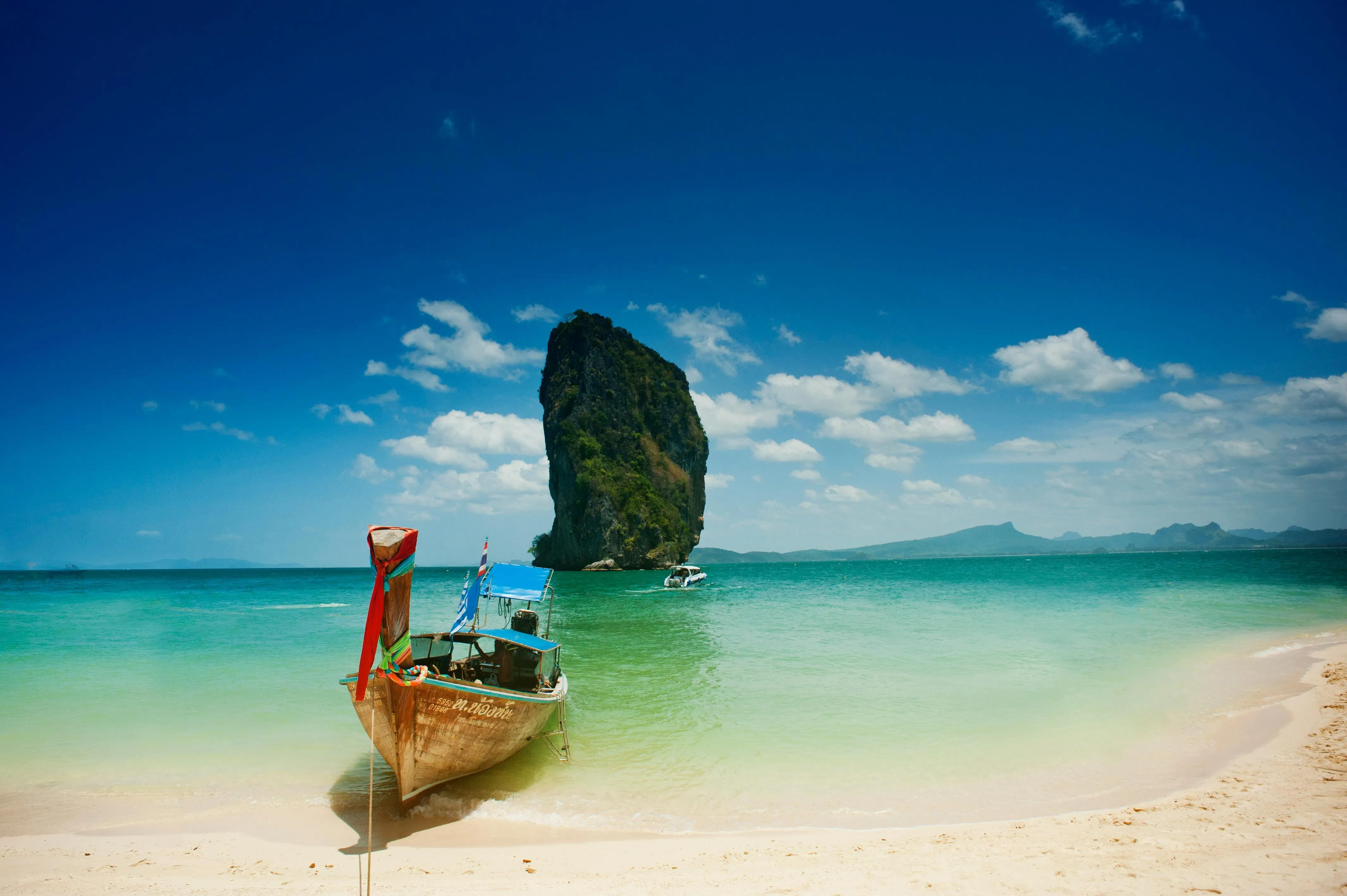Tropical beach with water and a wooden long tail boat image
