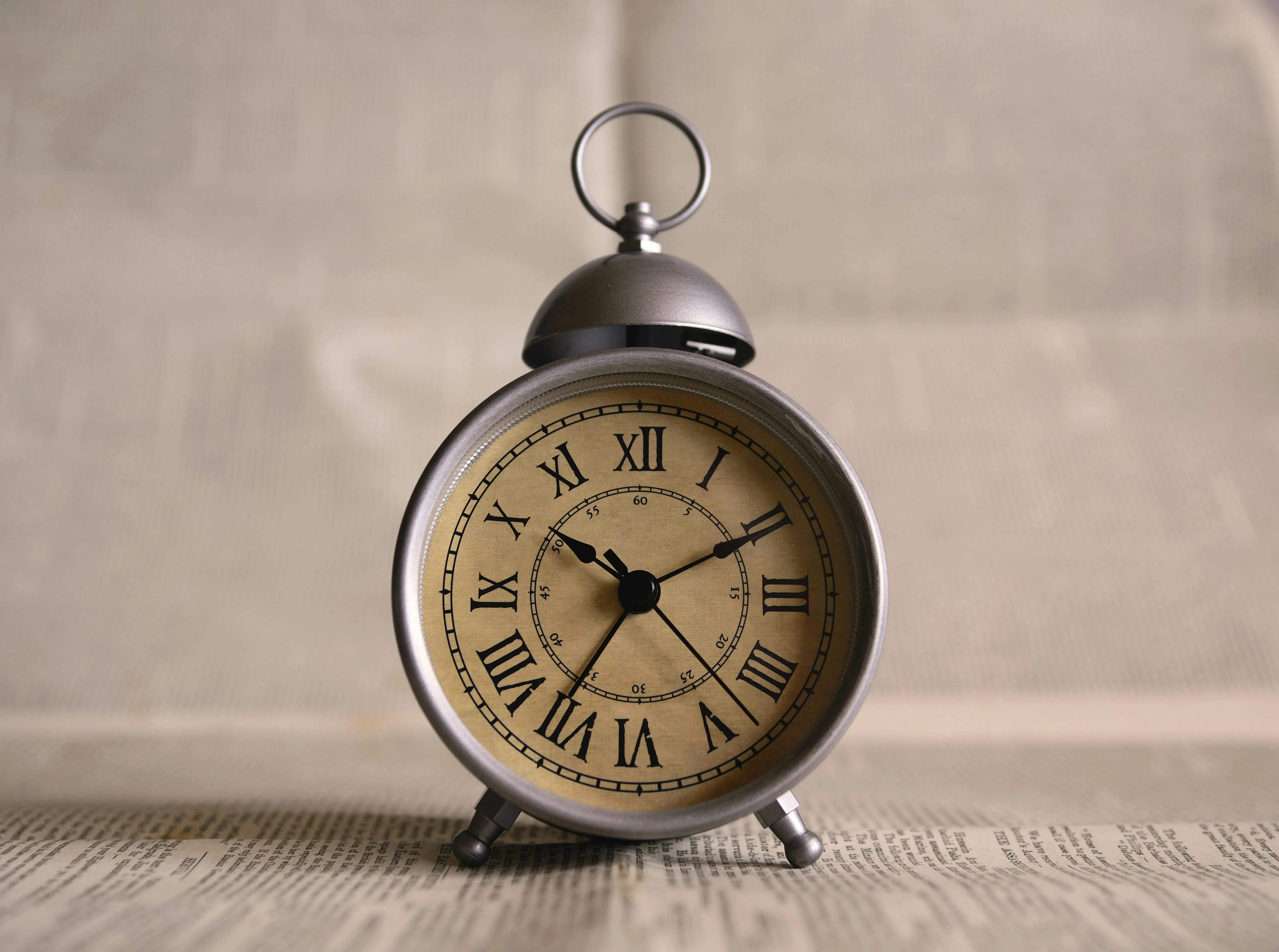 Vintage alarm clock on wooden surface close up Wallpaper