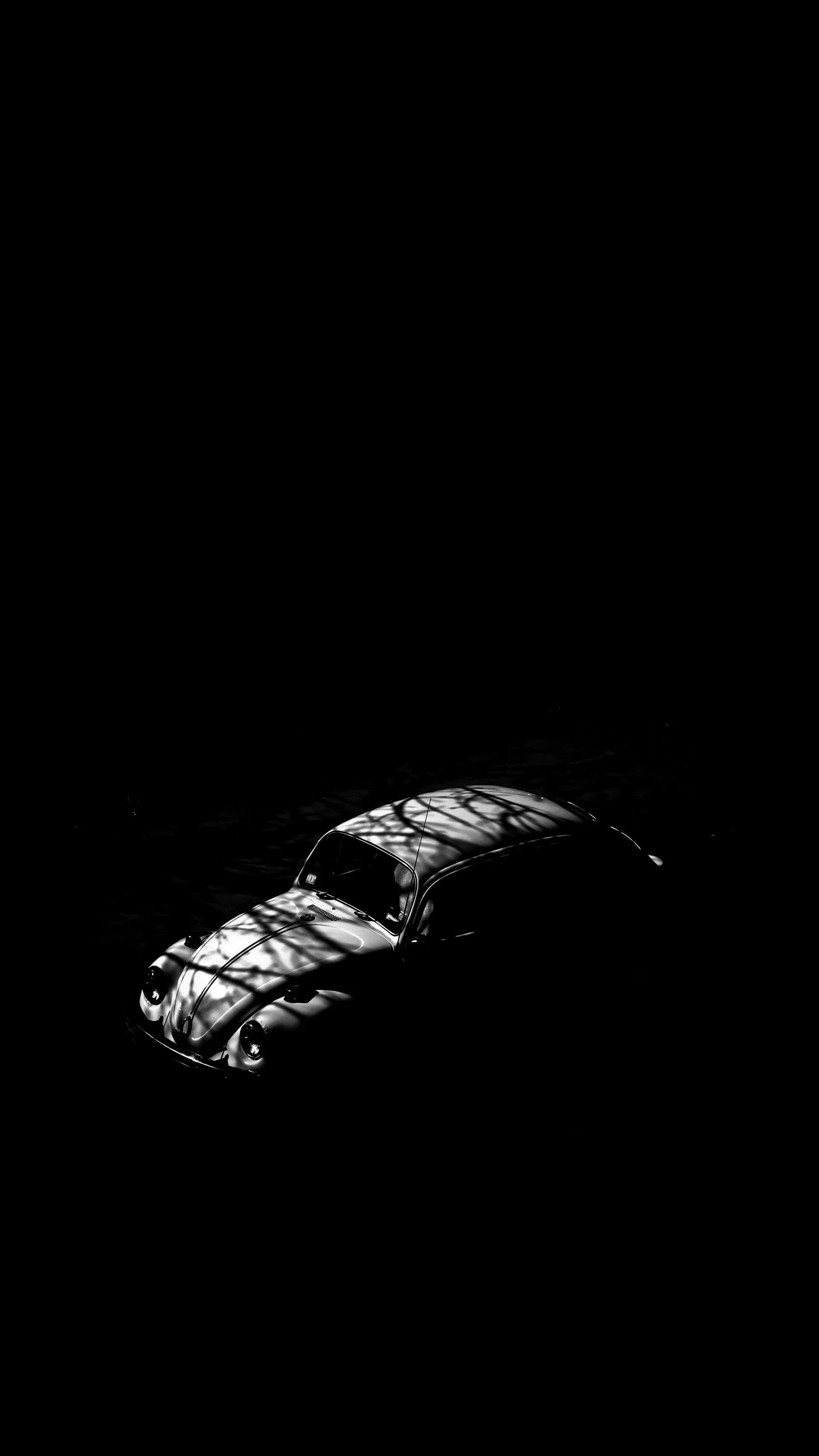 Vintage car in dramatic black shadow with soft light lines