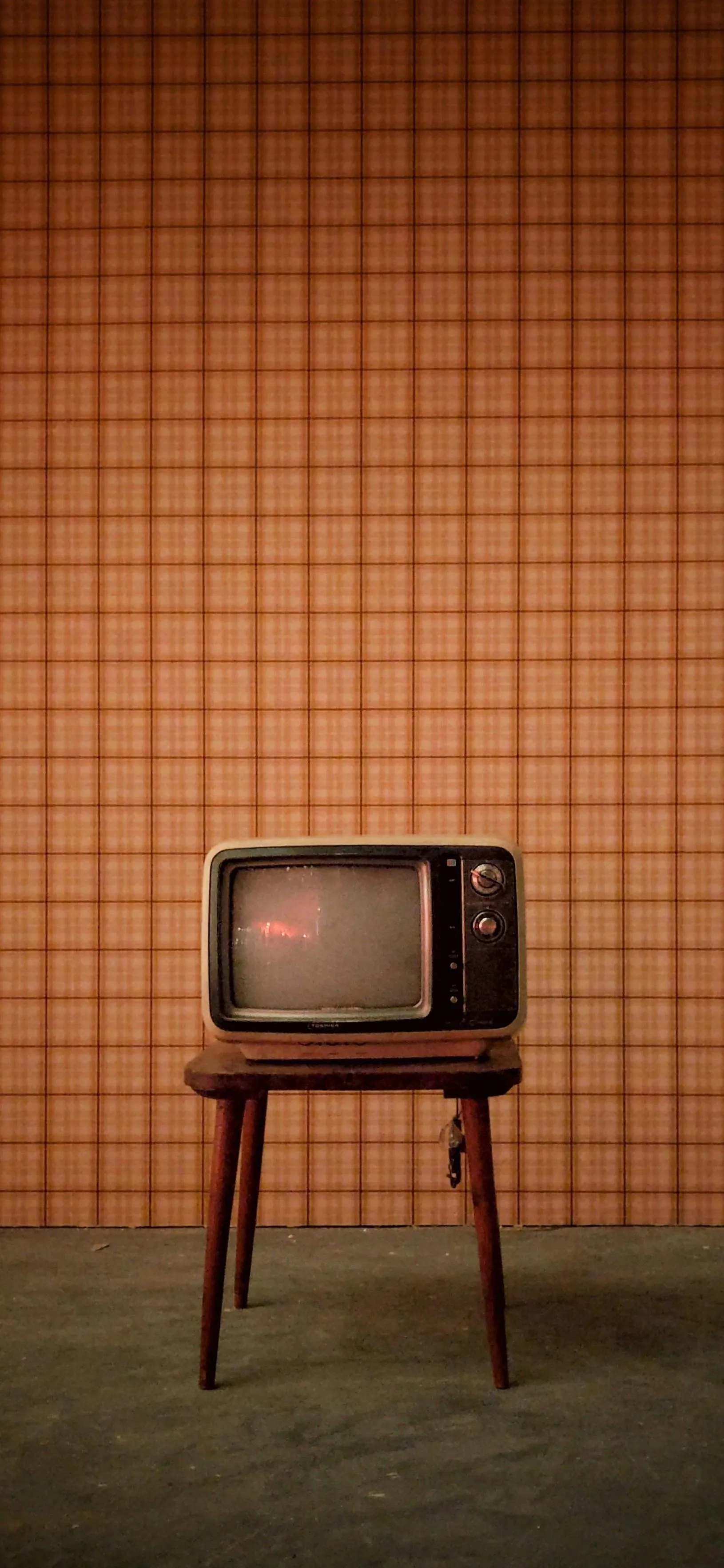 Vintage Television Set Against Retro Orange Wall Wallpaper