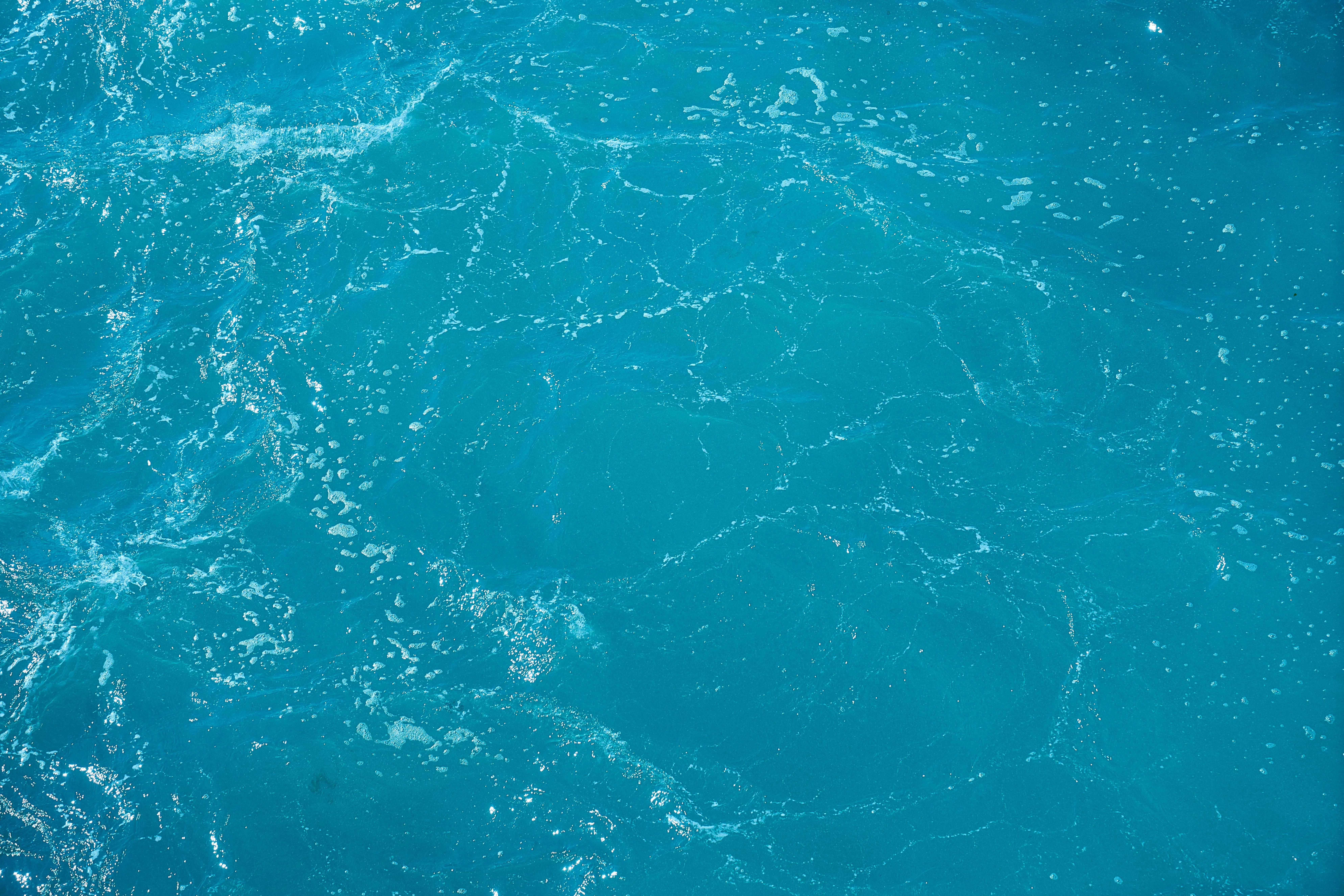 Water surface with gentle waves and sunlight reflections