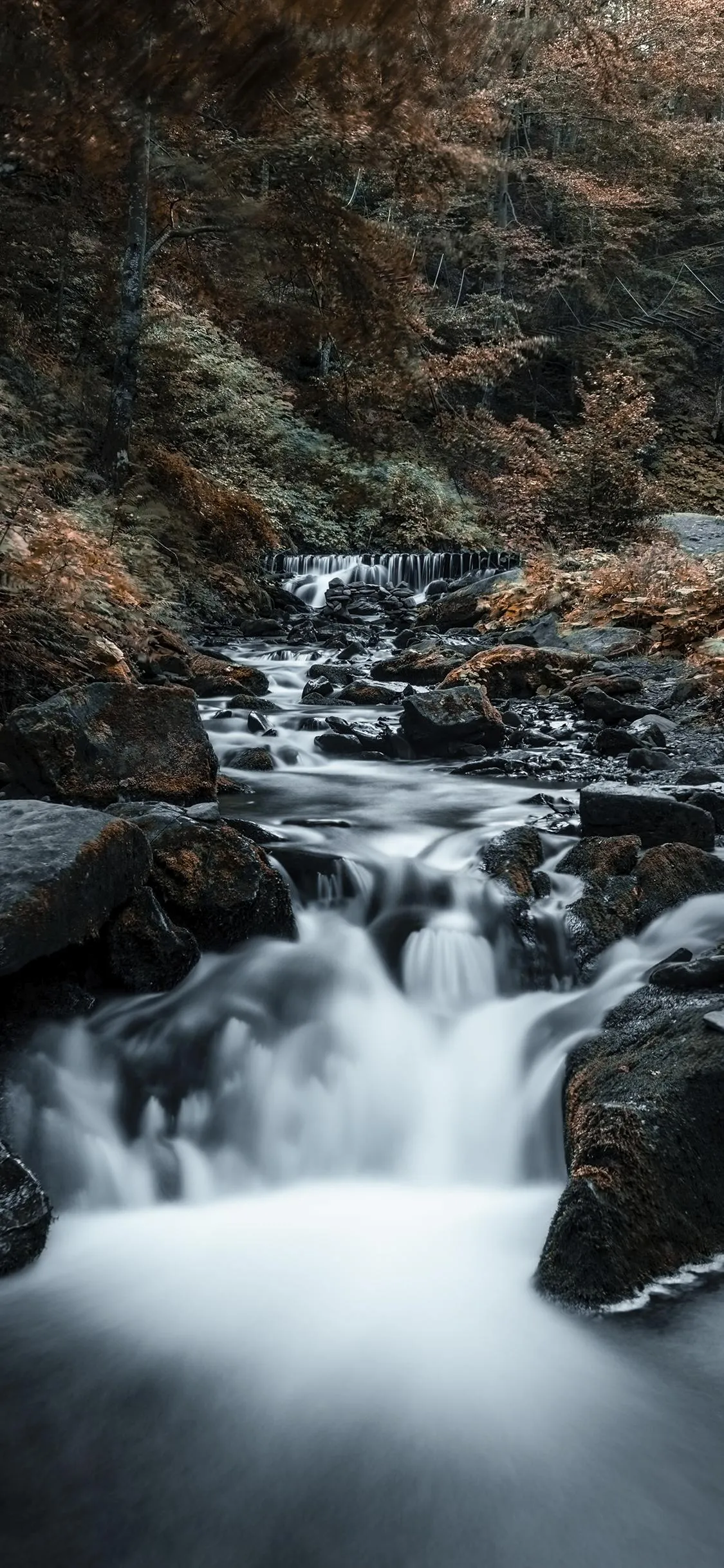 Waterfall Flowing in Forest with Rocks and Mist Wallpaper