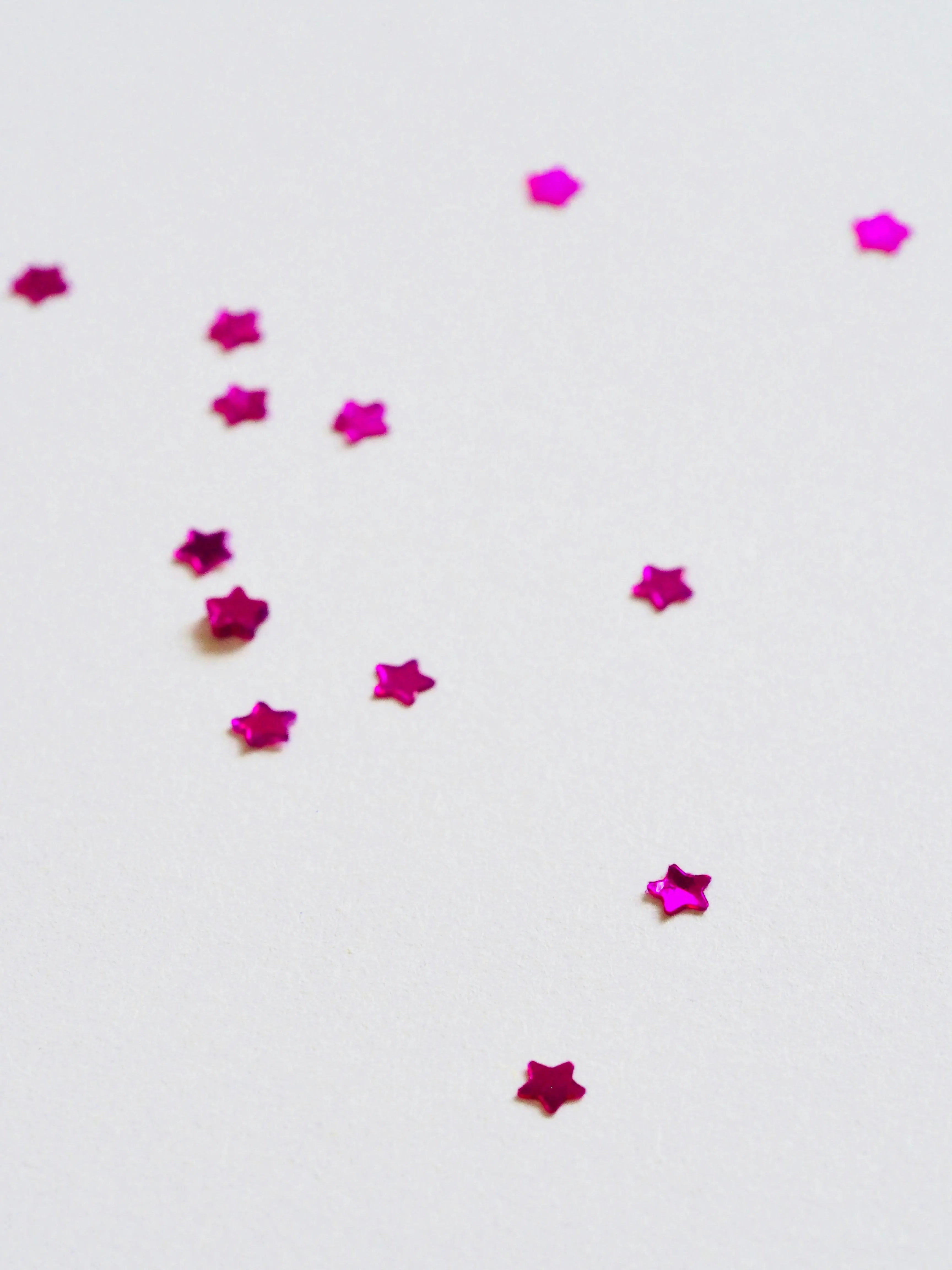 White background with scattered small pink star shapes