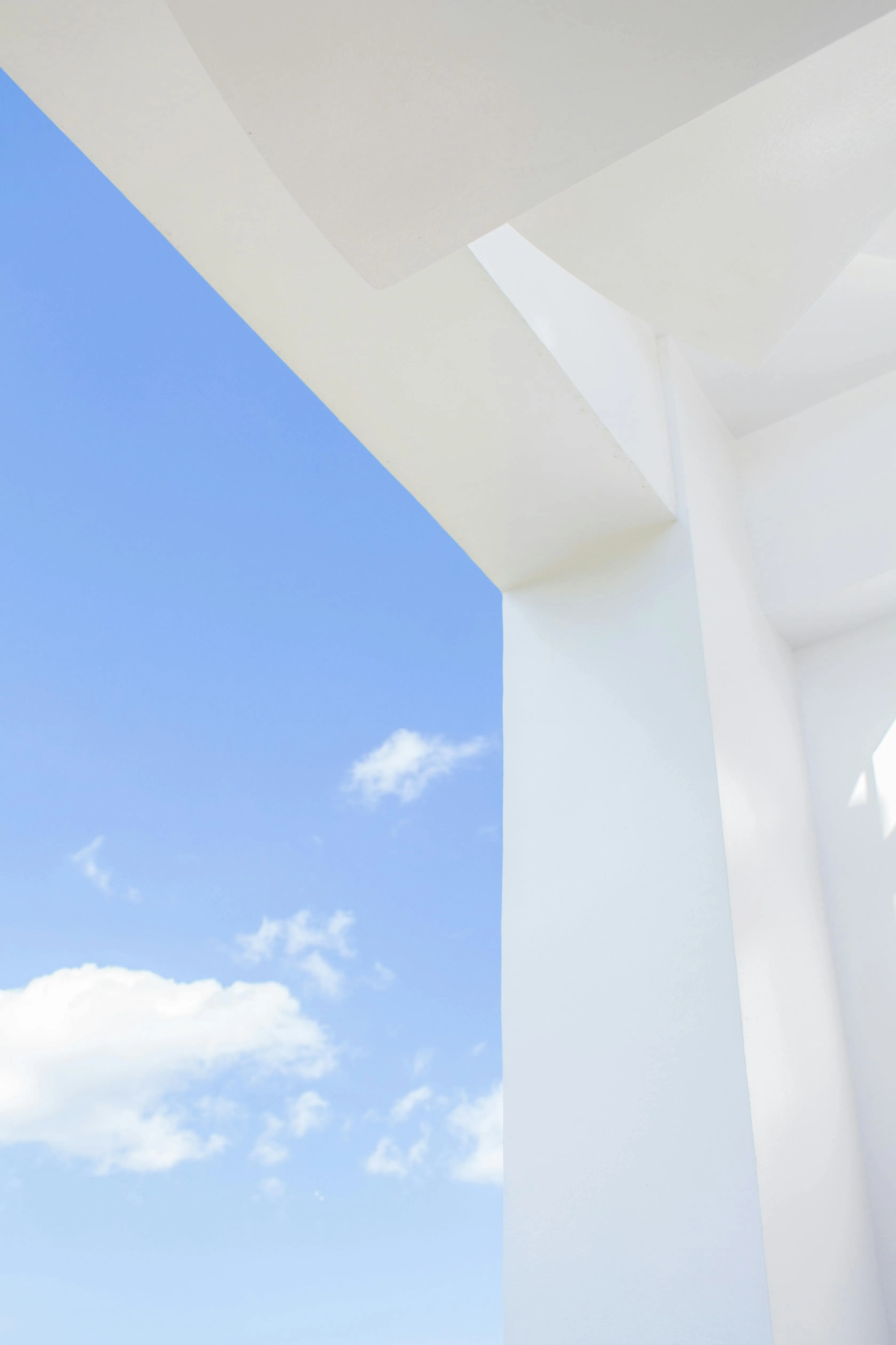 White bridge structure with blue sky and clouds background