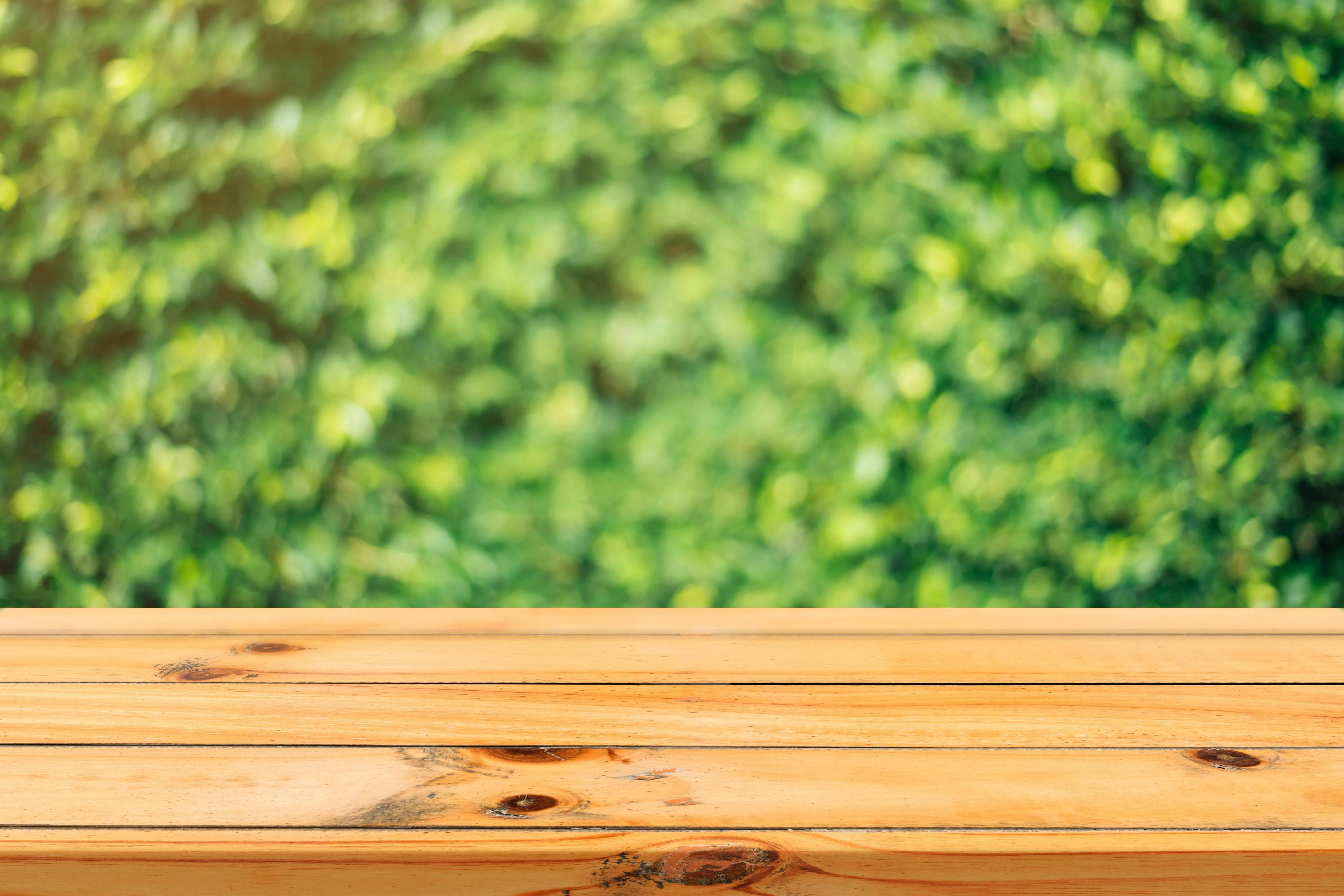 Wooden table top with green blurred background 4K image