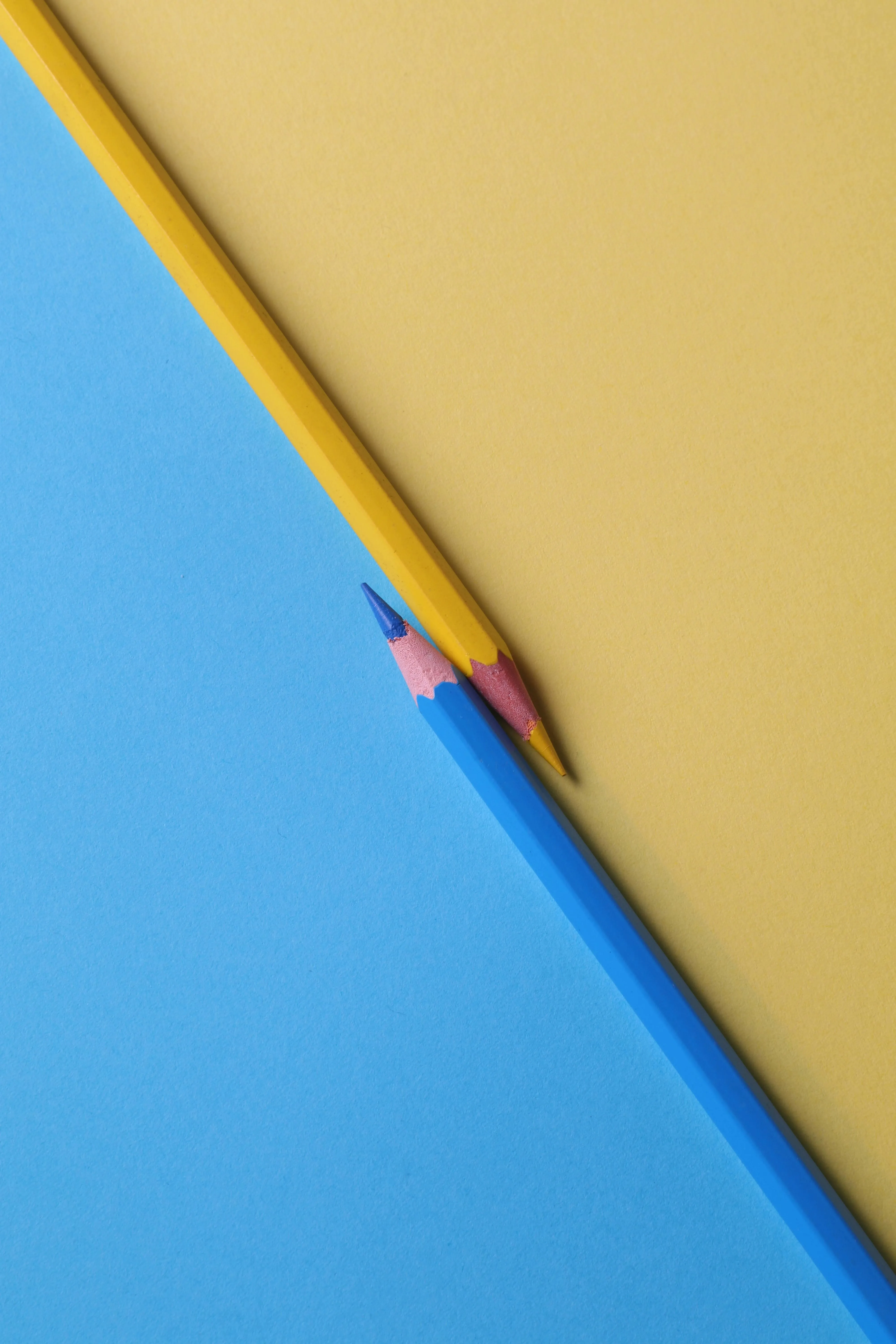 Yellow pencil on a blue and yellow two colour background