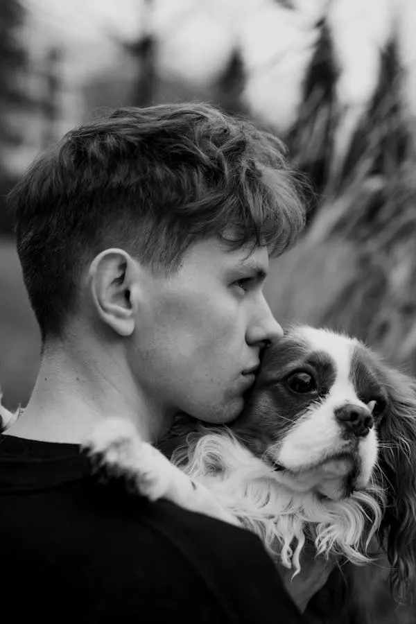 Black and White Image Of Man Kissing His Dog on Cheek