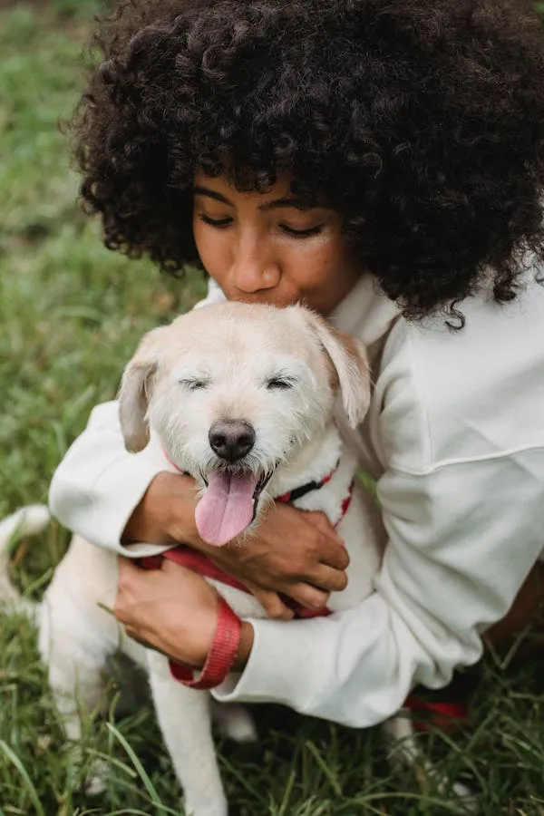Curled Hair Woman Kissing White Puppy in Sunny Garden