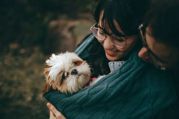 Happy Couple Hugging a Cute Little Puppy with Warm Smiles