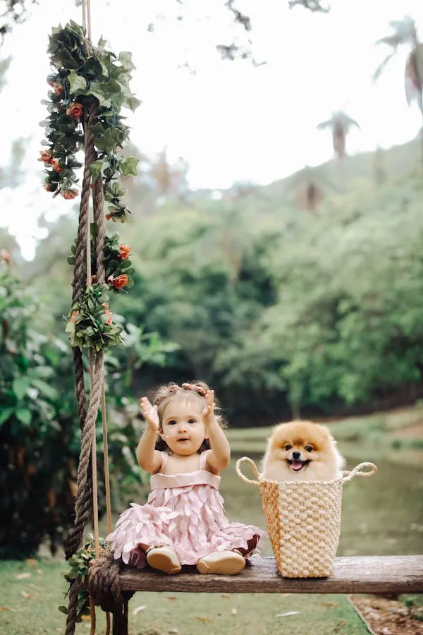 Little Girl Sitting on a Swing with Puppy in Basket Image