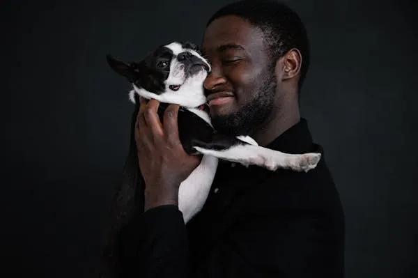 Man Hugging Puppy with Love and Smiling in Dark Background