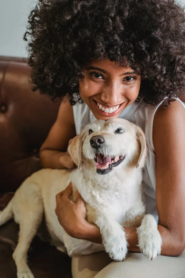 Smiling Woman Hugging a Happy White Dog at Home Wallpaper