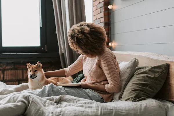 Woman Sitting on Bed Playing with Cute Puppy at Home Image