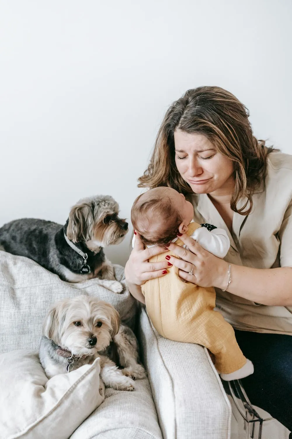 Woman Sitting with Baby and Puppies on a Cozy Couch Image
