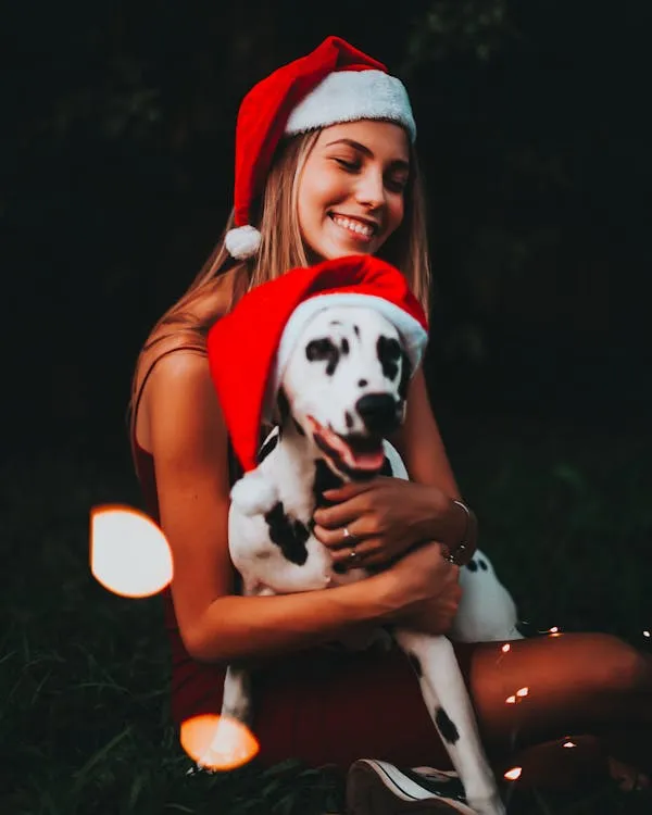Woman with Santa Hat Holding a Dalmatian Puppy Wallpaper