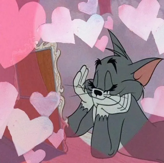 Tom smiling with heart shapes floating in the background