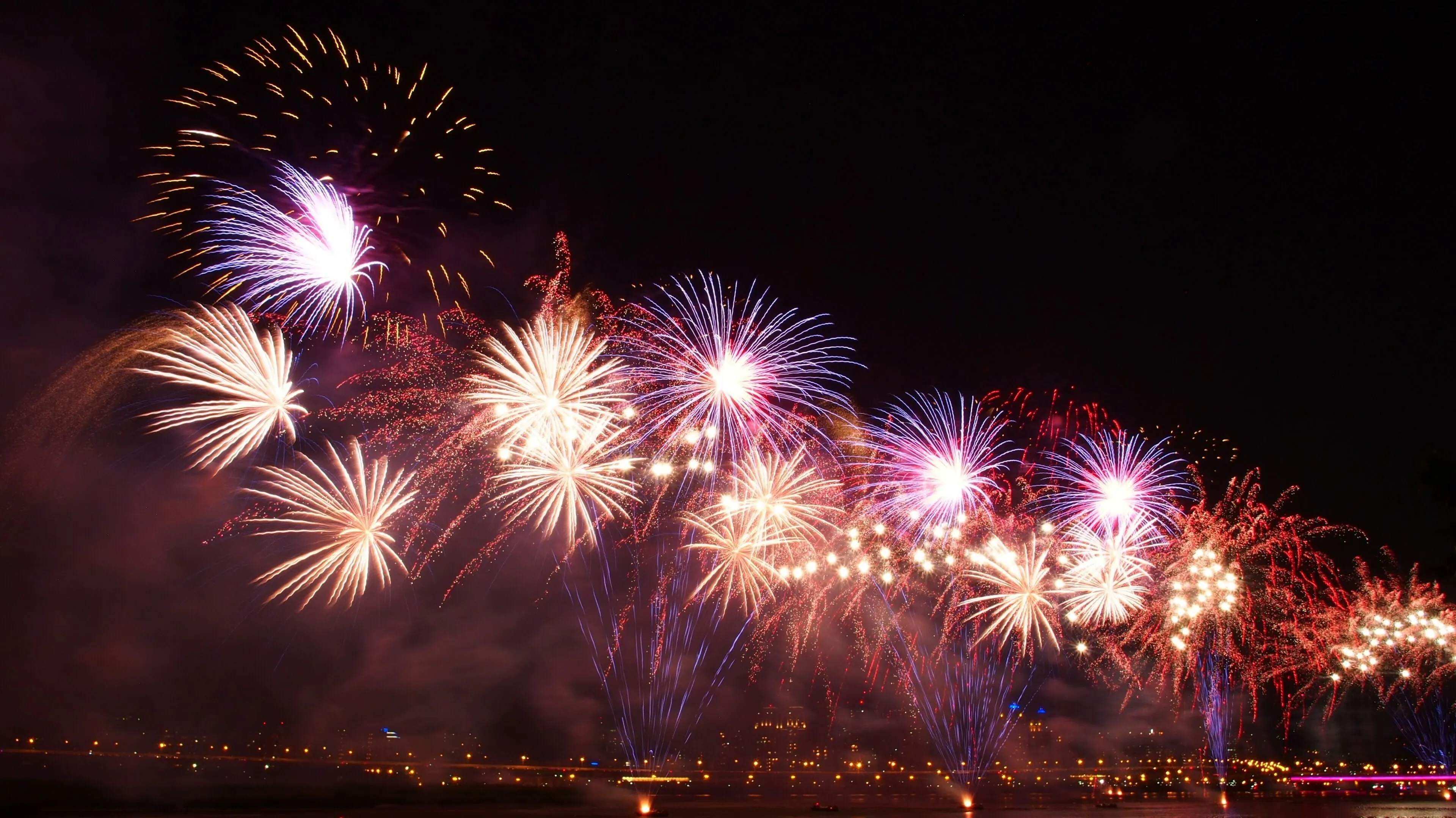 Colourful Fireworks with City Light at Night Wallpaper
