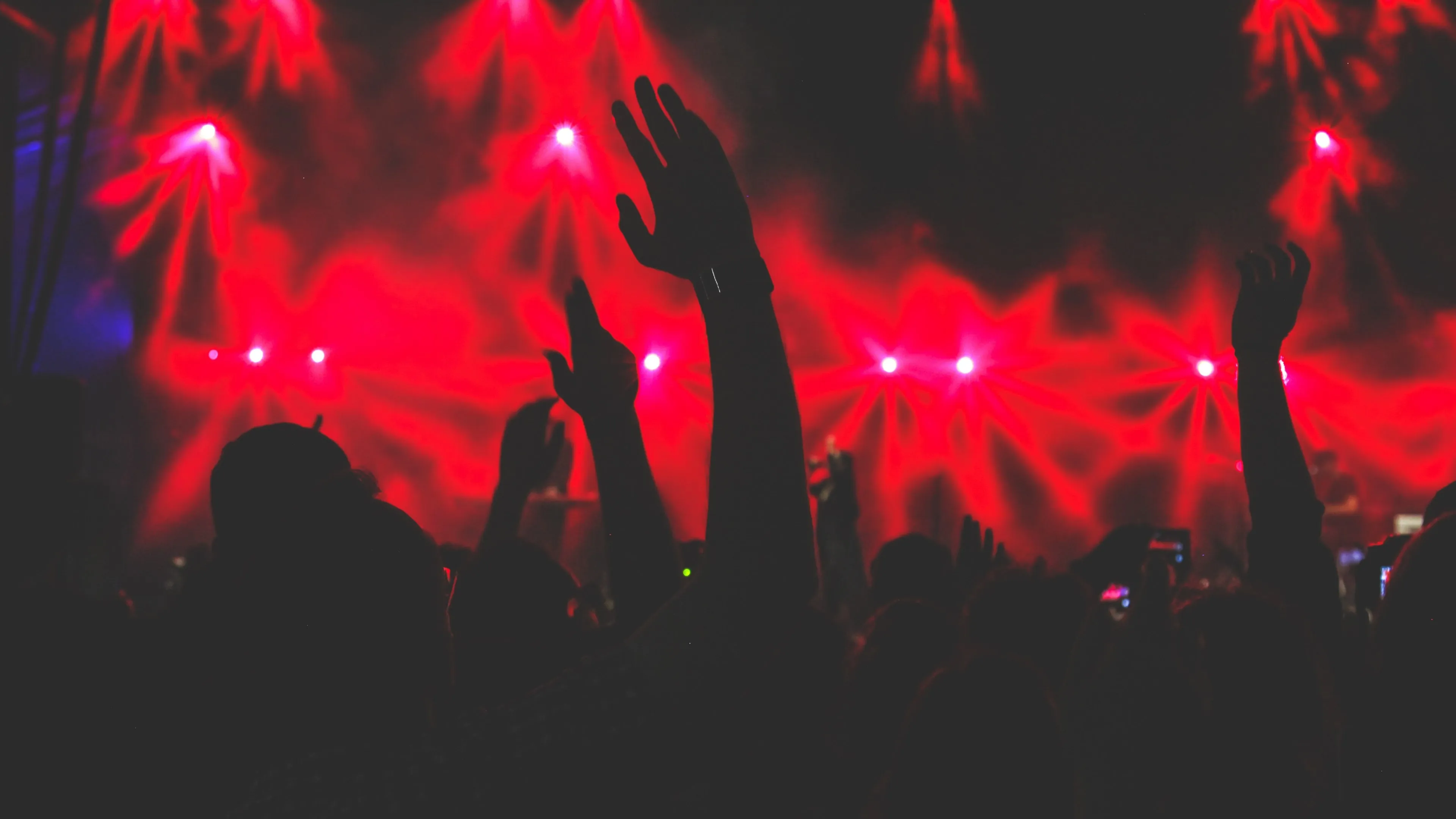 Energetic Concert Crowd with Red Lights and Music Vibes