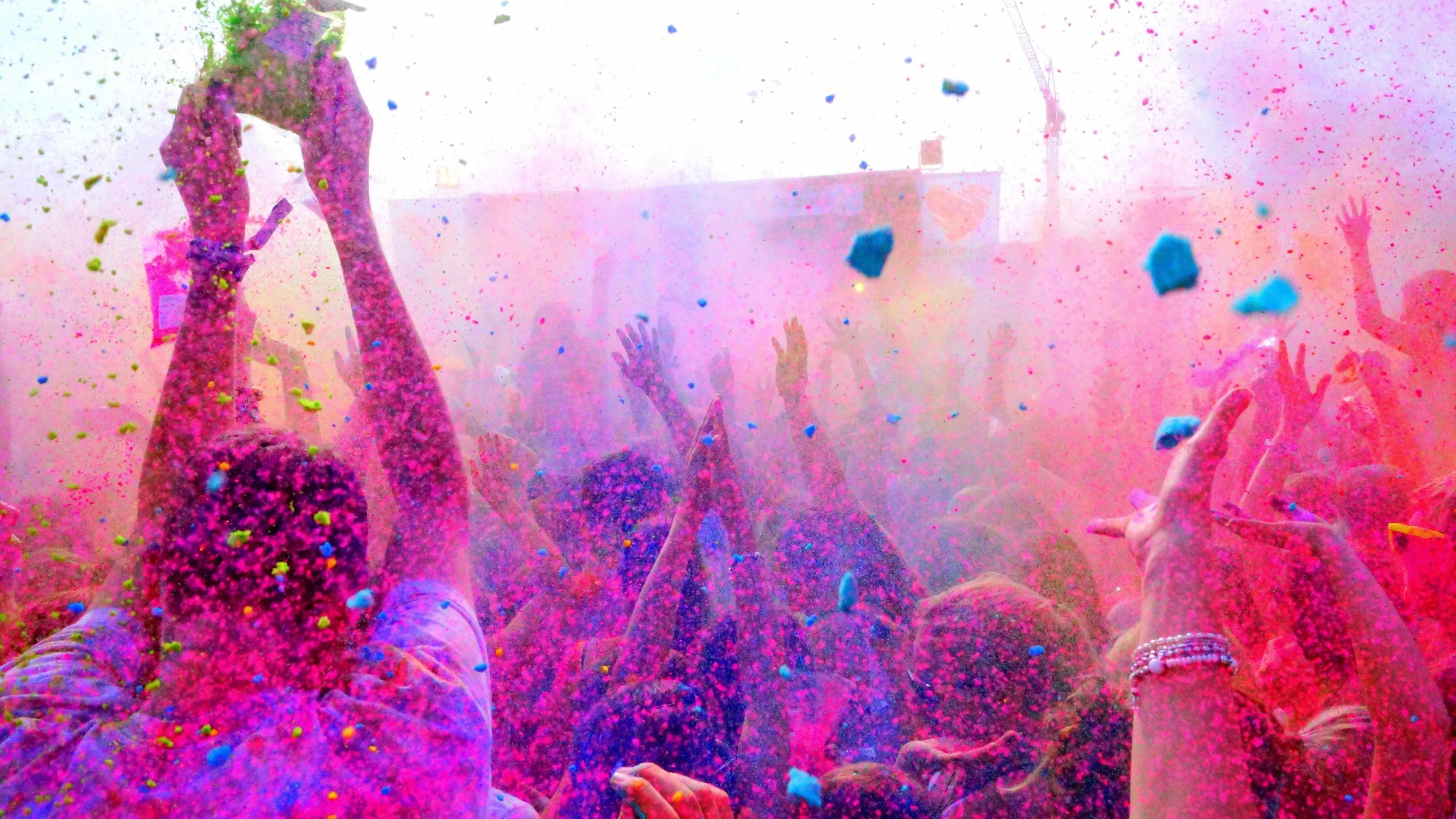 A Festival Where People Dancing in Coloured Powder Bursts