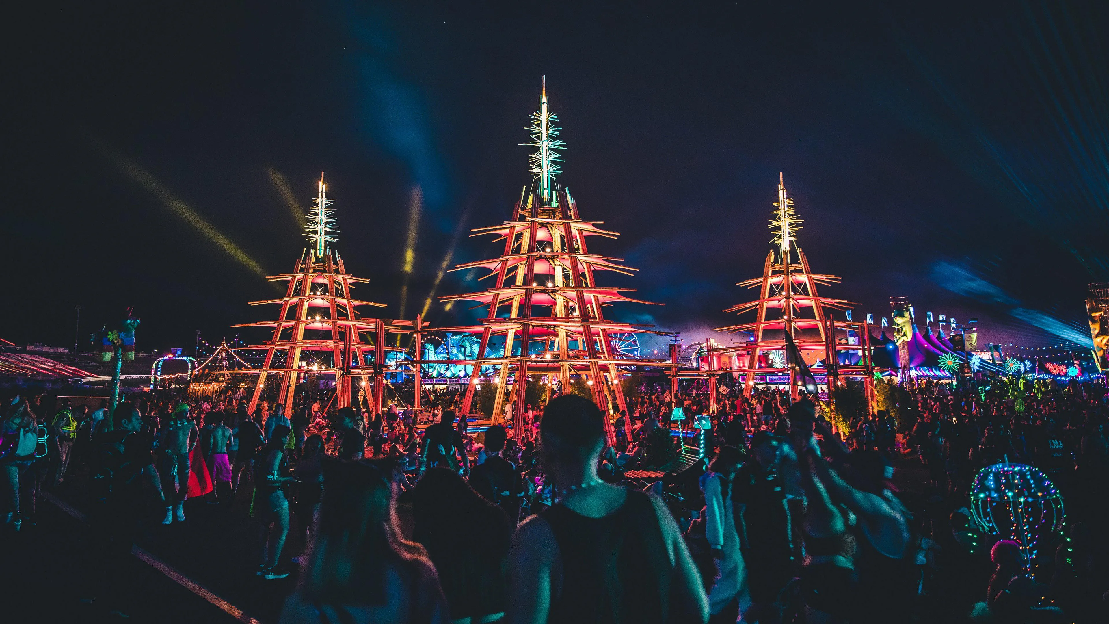 Vibrant Night Festival Scene with Lights and Crowd Wallpaper